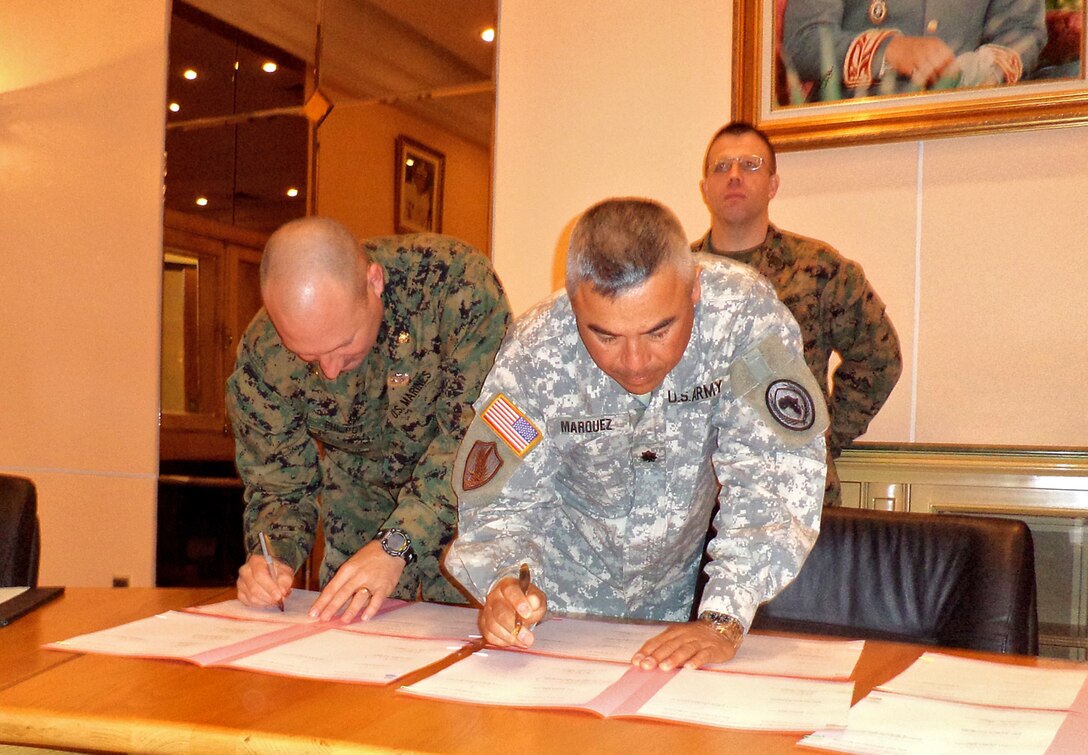 Major James Philpot, Marine Forces Africa lead planner for African Lion 13 and U.S. Army Lt. Col. Gregory Marquez, U.S. Embassy Morocco, OIC, security cooperation, sign the official minutes in the RAF headquarters in Agadir, Morocco, Jan. 30, confirming the planning for the multi-national exercise scheduled for April.  AL-13 is a U.S. African Command-sponsored, MFA-led exercise that involves various types of training including command post, live-fire and maneuvering, peace keeping operations, an intelligence capacity building seminar, amphibious operations, aerial refueling/low-level flight training, as well as medical and dental assistance projects.