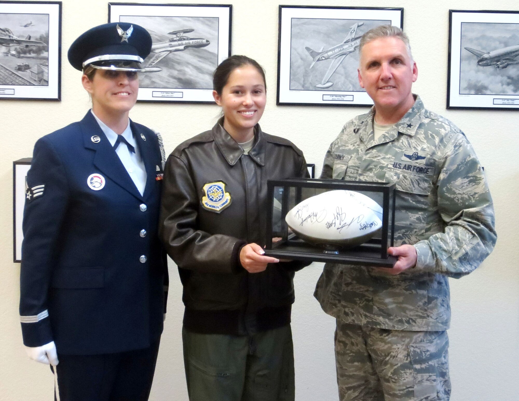 TRAVIS AIR FORCE BASE, Calif. -- Brig. Gen. John C. Flournoy, Jr., and Reserve Honor Guard member Senior Airman Tania McGuire presented Senior Airman Arriel Bromely, 6th Air Refueling Squadron, with a San Francisco 49ers autographed football that was donated by the 349th Honor Guard for silent auction. All proceeds was donated to the
349th Friends of Family on behalf of the 349th Honor Guard members. (U.S. Air Force photo by T.C. Perkins) 