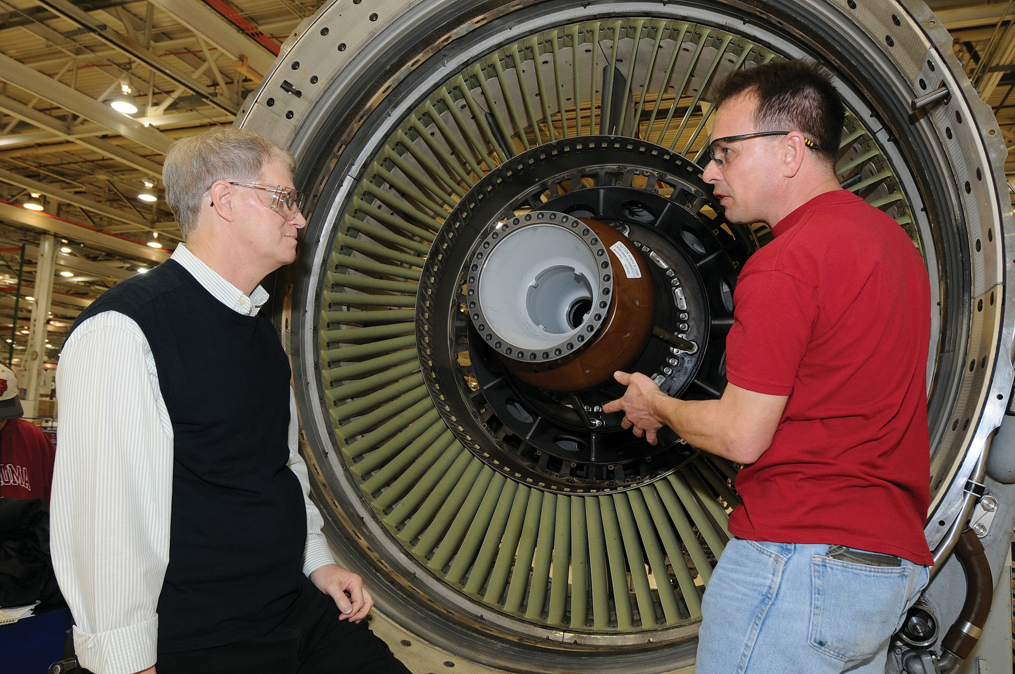 Reaping positive benefits of the relationship between the Air Force Life Cycle Management Center and the Air Force Sustainment Center, engineers and mechanics work to quickly resolve any repair issues during production here at Tinker. In Bldg. 9001’s F108 Navy/Air Force engine shop, aerospace engineer Michael Denny, left, and engine mechanic Rick Thompson discuss the life cycle fatigue and possible routine maintenance requirements of the number 1-2 bearing support. (Air Force photo by Margo Wright)