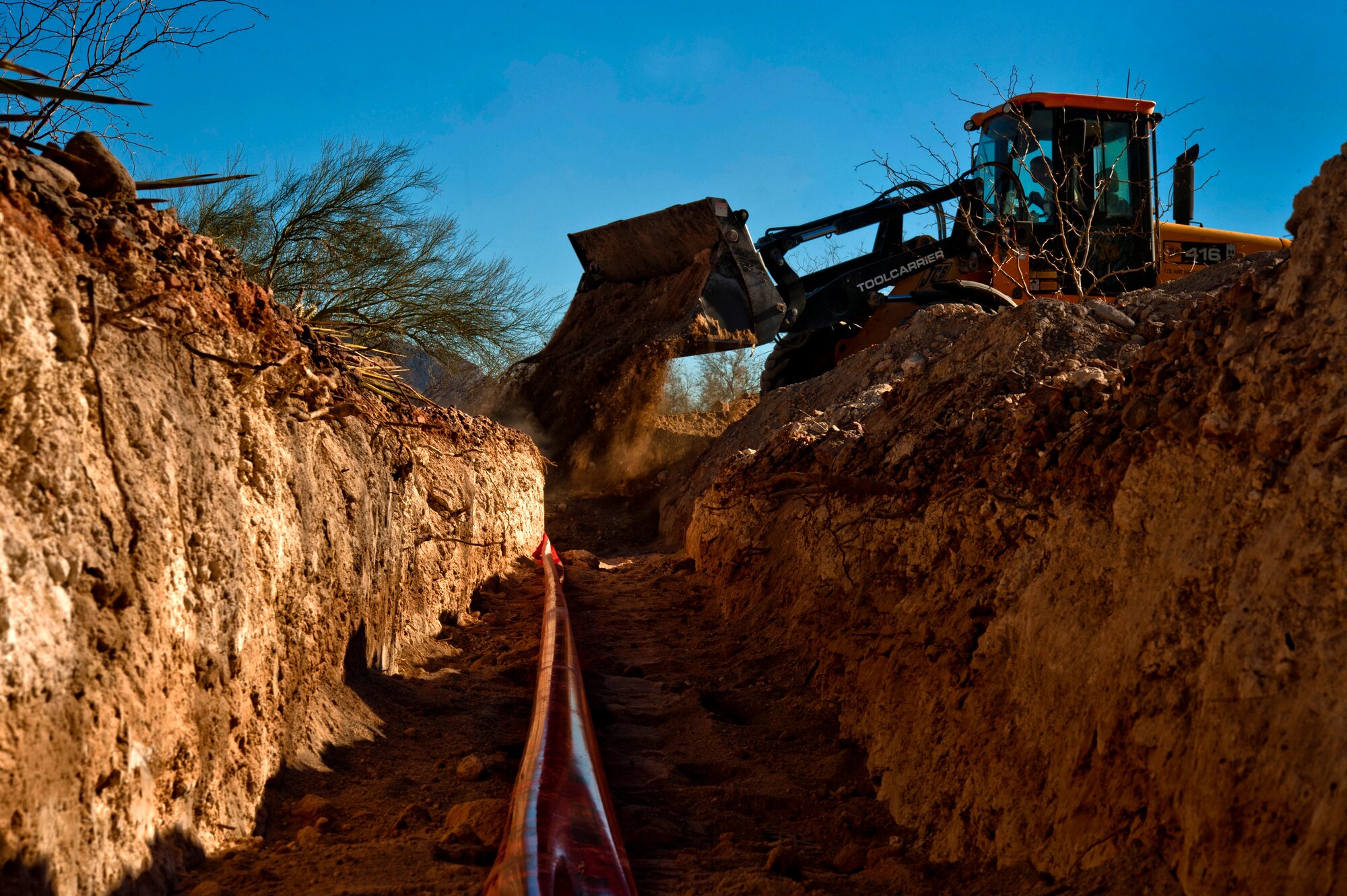 An Airman from the 99th Civil Engineer Squadron dumps dirt on top of piping Feb. 4, 2013, at Nellis Air Force Base, Nev. This is for new pop up barriers which will be installed after the new roundabout near the Beale gate. (U.S. Air Force by Photo Senior Airman Daniel Hughes)
