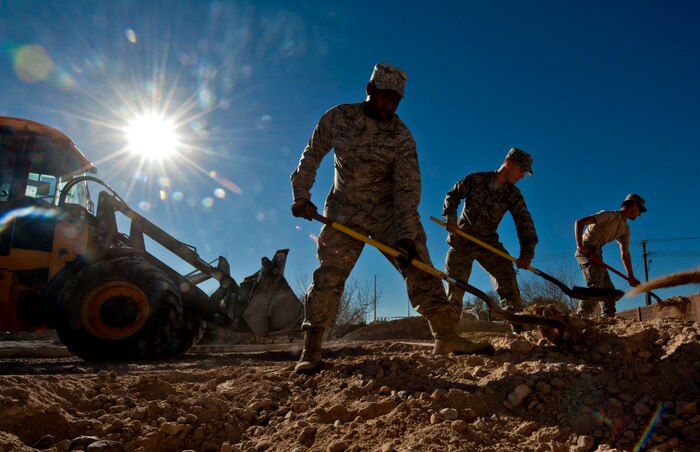 Airmen from the 99th Civil Engineer Squadron cover piping for a pop up barrier conduit Feb. 4, 2013, at Nellis Air Force Base, Nev. The new pop up barriers will be installed to prevent gate runners from entering the base. (U.S. Air Force by Photo Senior Airman Daniel Hughes)