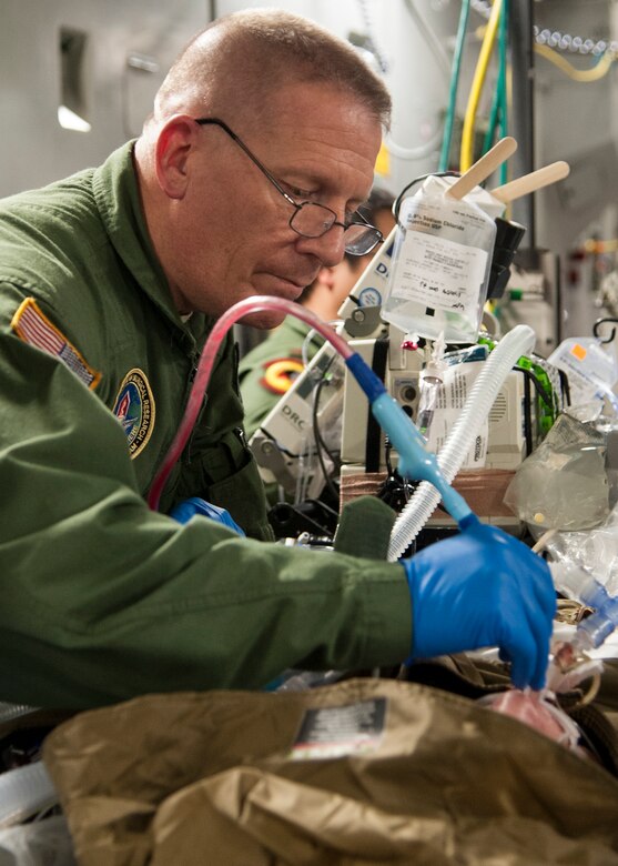 U.S. Army Capt. Michael Campbell, an Institute of Surgical Research burn flight team member at the San Antonio Military Medical Center, tends to a patient receiving treatment with an extracorporeal membrane oxygenation system on a C-17 Globemaster III, Jan. 16 at Joint Base San Antonio-Lackland, Texas. ECMO is a heart-lung bypass system that circulates blood through an external artificial lung and sends it back into the patient’s bloodstream. (U.S. Air Force photo/Staff Sgt. Kevin Iinuma)