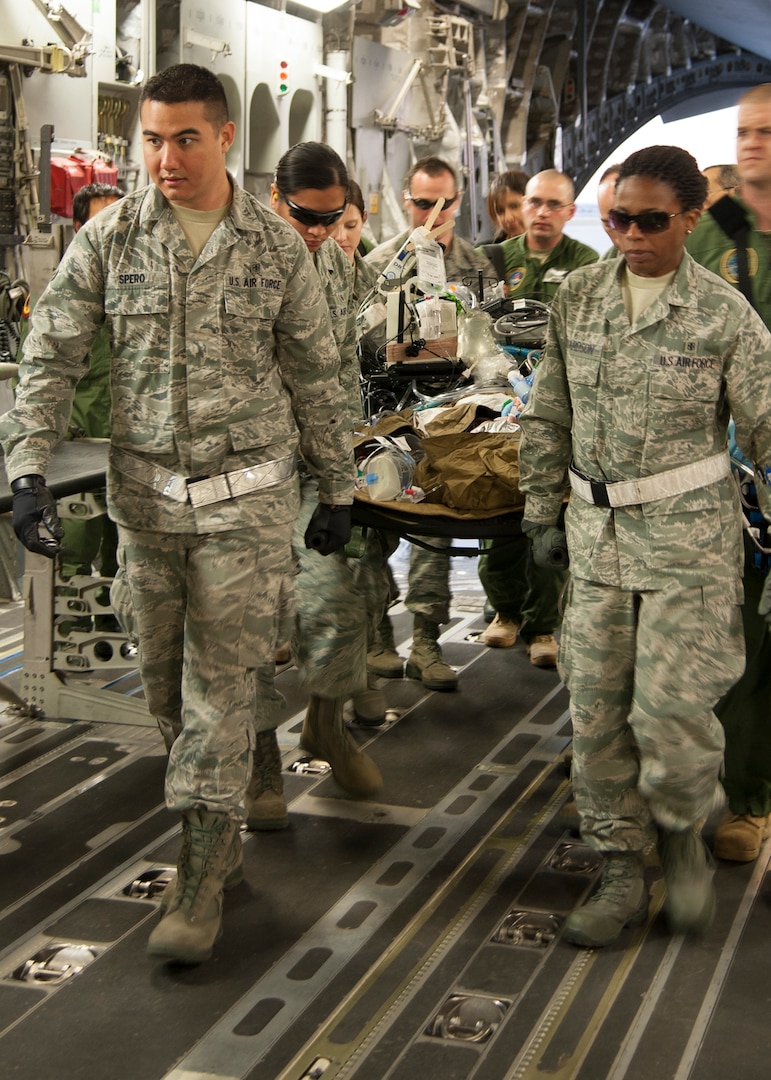 Members of the 59th Medical Wing Aeromedical Staging Facility transfer a patient being treated with an extracorporeal membrane oxygenation system into a C-17 Globemaster III, Jan. 16 at Joint Base San Antonio-Lackland, Texas.  ECMO is a heart-lung bypass system that circulates blood through an external artificial lung and sends it back into the patient’s bloodstream. (U.S. Air Force photo/Staff Sgt. Kevin Iinuma)