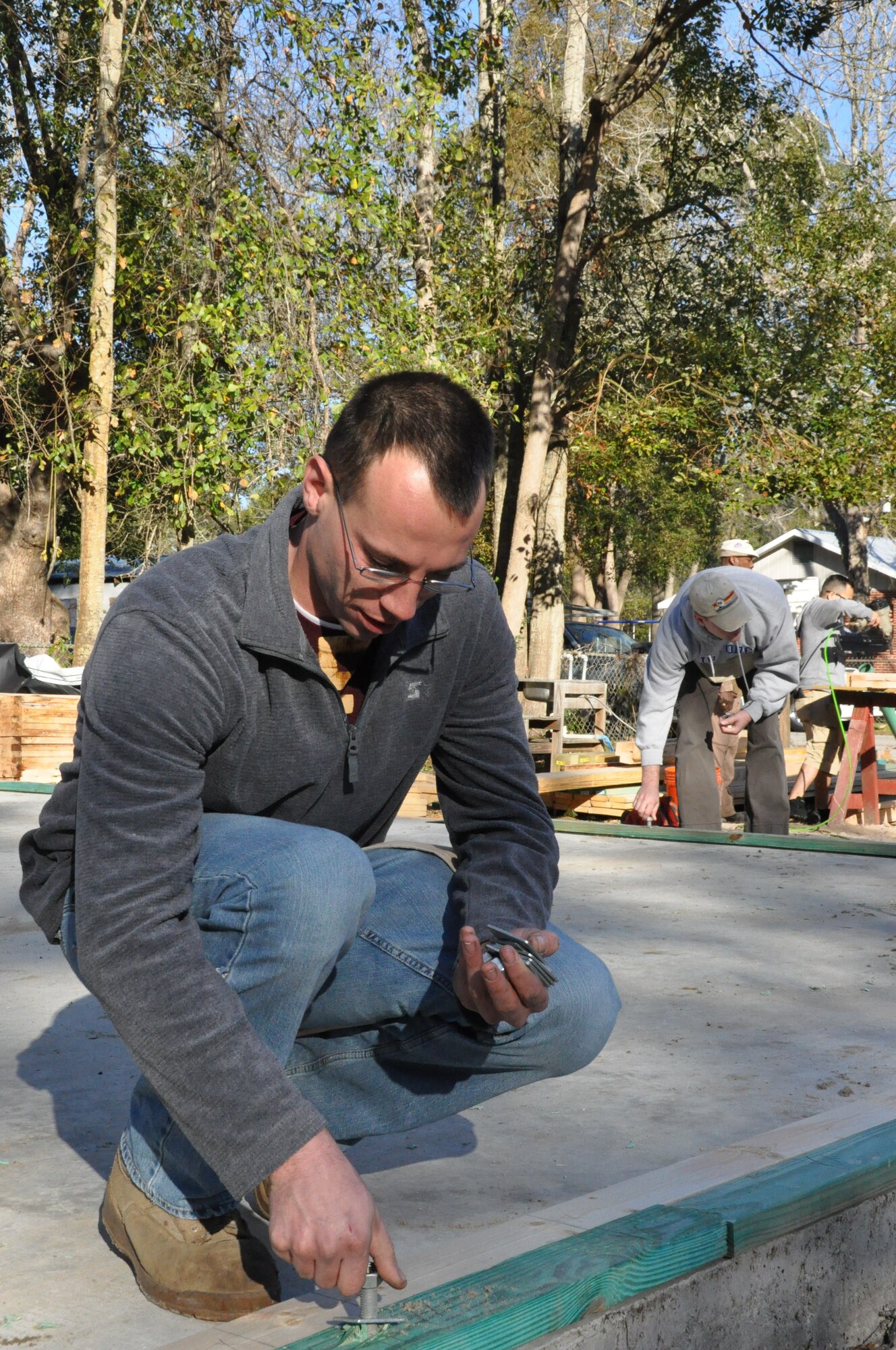Senior Airman Christopher Blake, 325th Maintenance Squadron Aerospace Ground Equipment personnel, adds nuts to foundation bolts in order to help build the foundation for a Bay County Habitat for Humanity home Feb. 2. (U.S. Air Force photo by Staff Sgt. Rachelle Elsea)