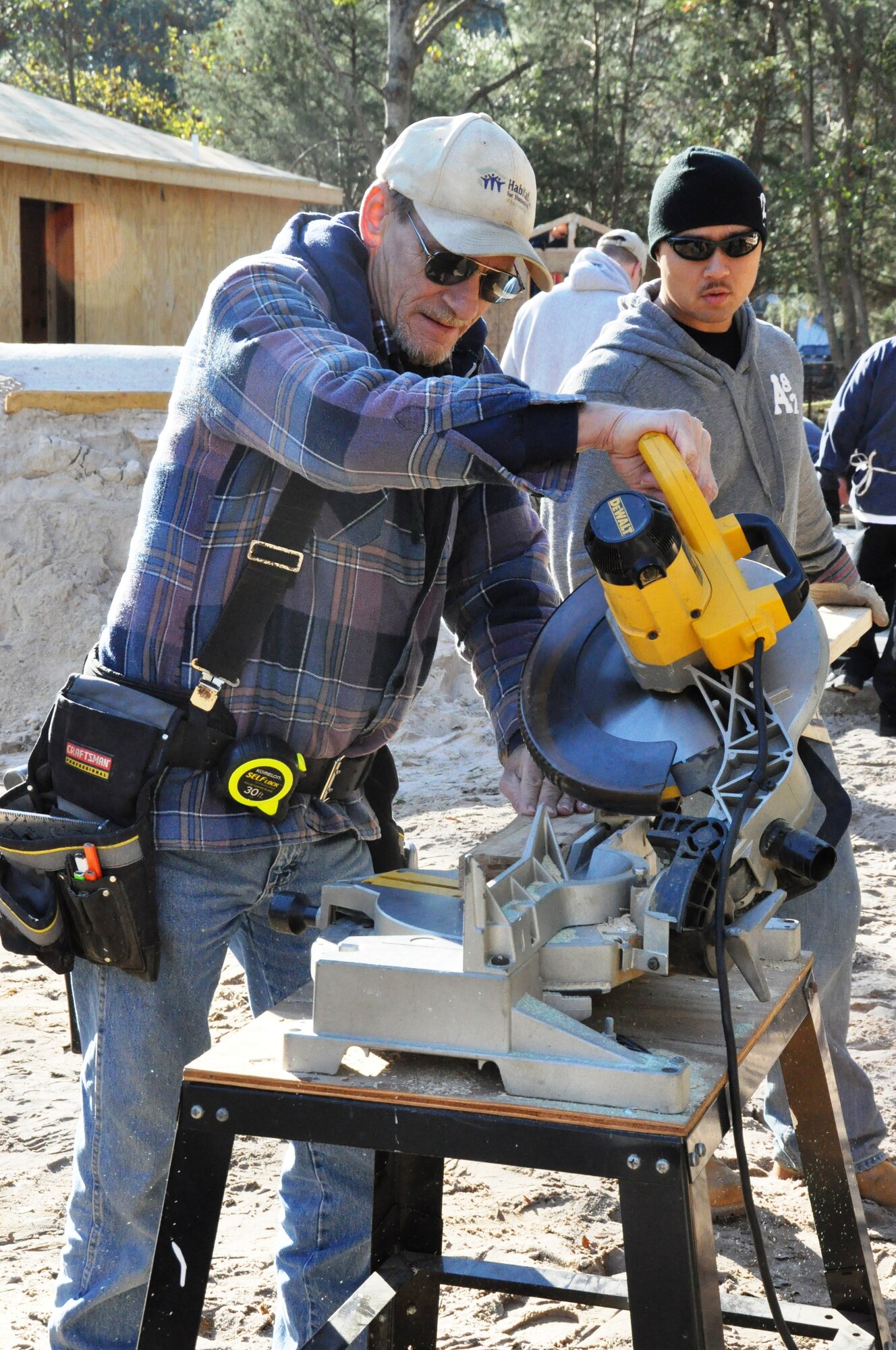 Staff Sgt. Daniel Schlemmer, 325th Maintenance Squadron Aerospace Ground Equipment personnel, and a local volunteer, cut wood to help build the foundation for a Bay County Habitat for Humanity home Feb. 2. (U.S. Air Force photo by Staff Sgt. Rachelle Elsea)