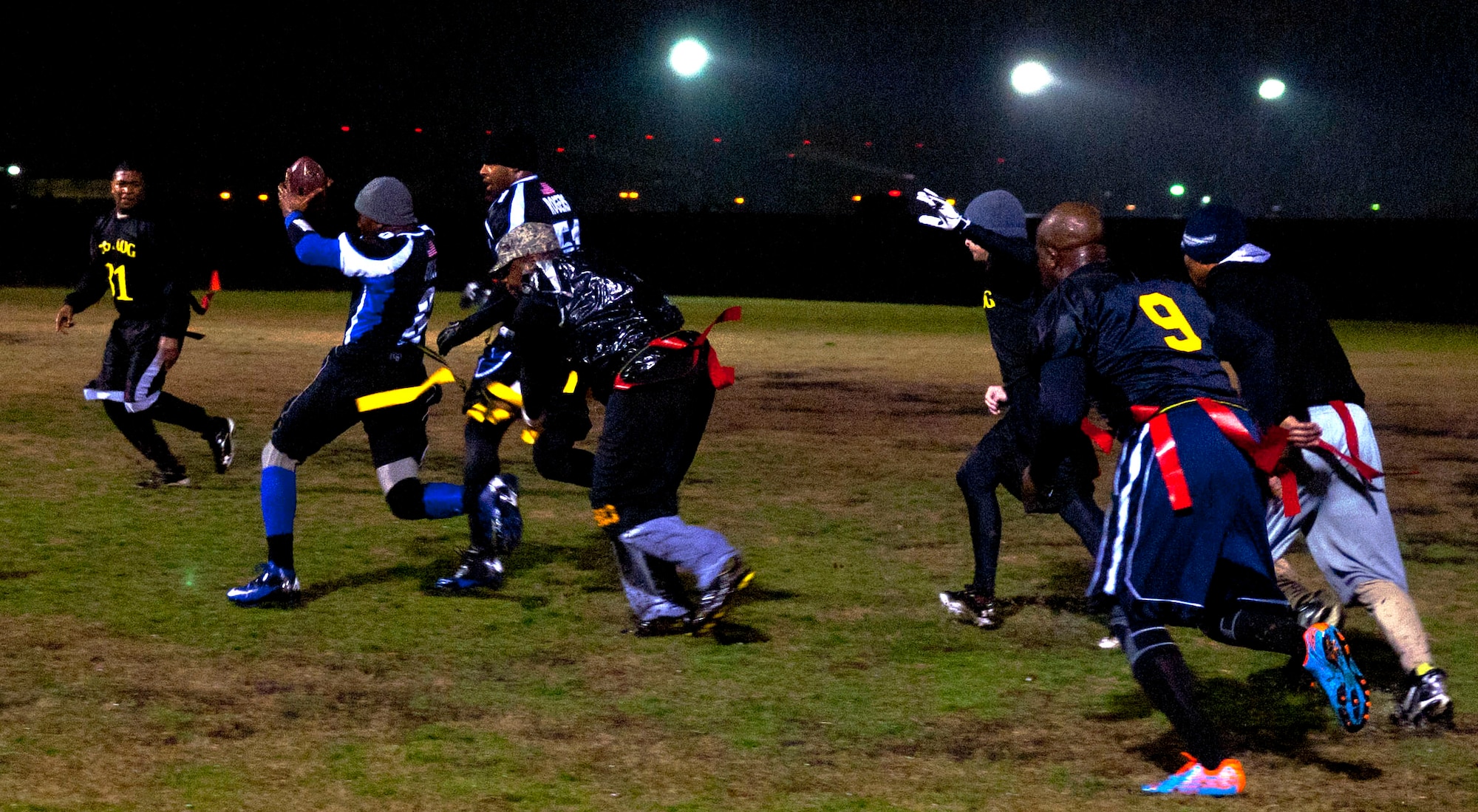 Senior Airman Antonio Grace, 633rd Security Forces head football coach, nearly escapes from a 735th Supply Chain Operations Group defender at Langley Air Force Base Jan. 14. Players from other teams refereed games in order to ensure fairness. (U.S. Air Force photo by Airman 1st Class Austin Harvill/Released) 
