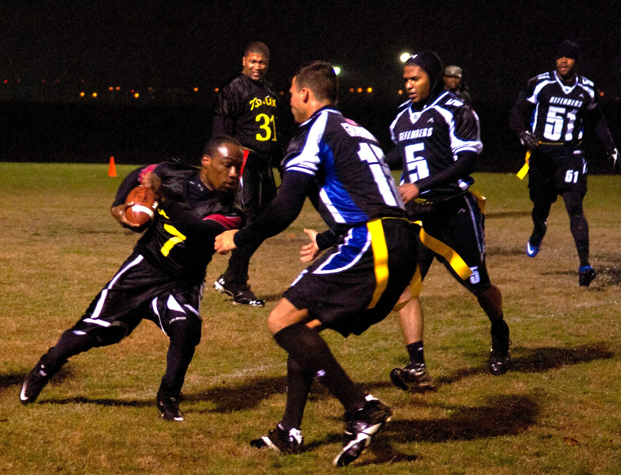 Two 633rd Security Forces Squadron defenders rush the 735th Supply Chain Operations Group quarterback after an attempted quarterback sneak at Langley Air Force Base Jan. 14. The league was divided into two divisions and 21 teams for the season. (U.S. Air Force photo by Airman 1st Class Austin Harvill/Released) 