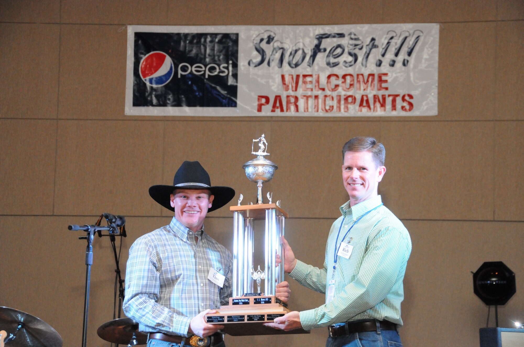 KEYSTONE, Colo. -- Col. Tim Gibson (left), 10th Air Base Wing commander at the U.S. Air Force Academy, presents the SnoFest commander’s trophy to Col. Richard Burchfield, individual mobilization augmentee to the 21st Space Wing commander, Jan. 26 at Keystone Resort. The trophy is awarded annually to the installation with the two fastest skiers and snowboarders competing at the SnoFest weekend. The winning team consisted of skiers Roger Wolf, Space and Missile Systems Center, and Jim Waltman, Air Force Space Command, and snowboarders Brad Boyer, Defense Intelligence Agency and OC O’Connor, AFSPC. (Photo courtesy/Herb Wetzel)