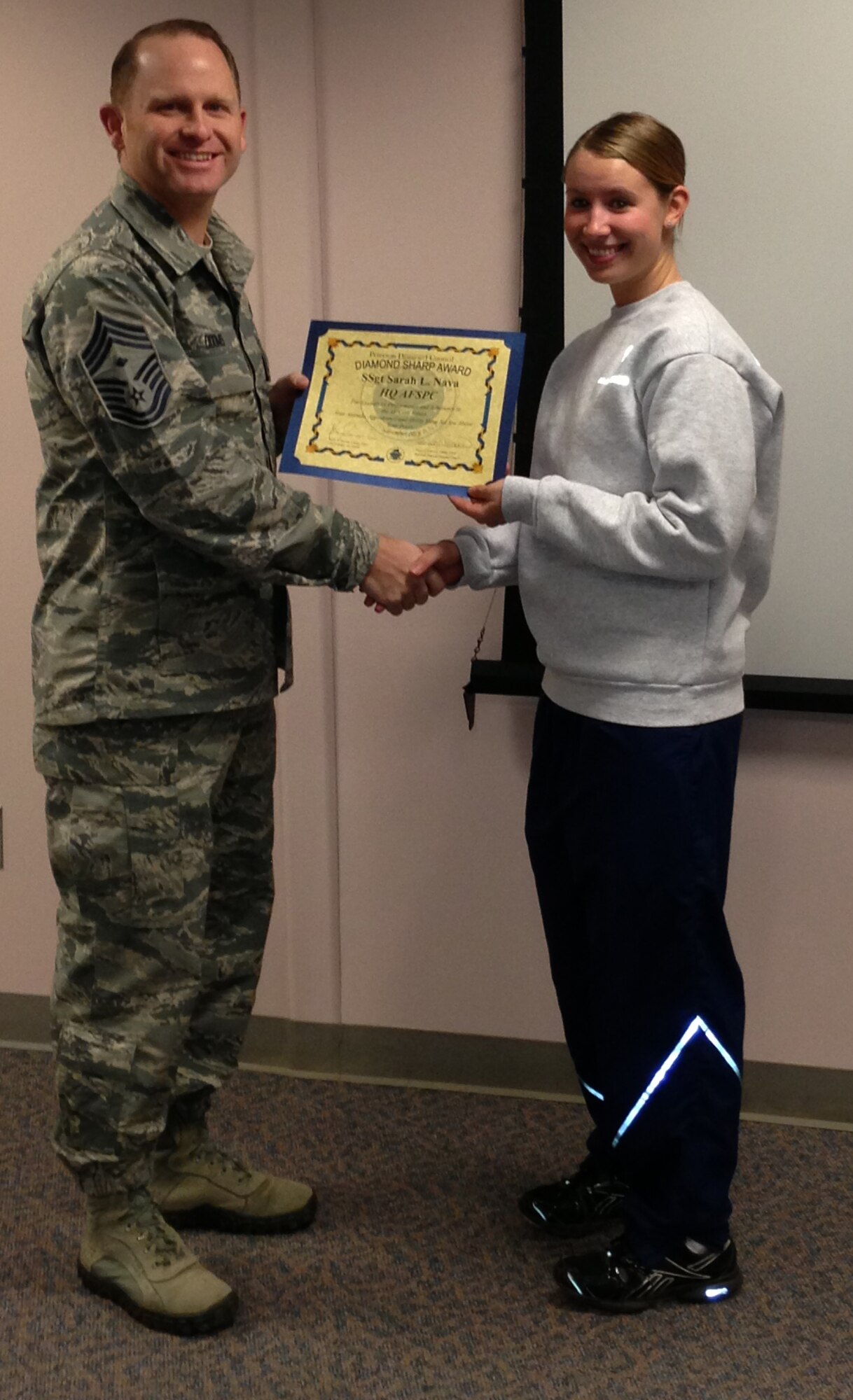 PETERSON AIR FORCE BASE, Colo. – Chief Master Sgt. Kevin Dooms, Headquarters Air Force Space Command first sergeant, presents the Team Peterson First Sergeants Council Diamond Sharp Airman award to Staff Sgt. Sarah Nava. Nava is part of the HQ AFSPC commander’s support staff. The award recognizes Airmen who go beyond their everyday tasks and demonstrate a high level of excellence, specifically in customer service and professional appearance. The Sharp Warrior Award is awarded each month in recognition of Team Petersons’ best. Any first sergeant or senior NCO serving as a first sergeant who observes outstanding performance may nominate someone for the award to the first sergeants council. (U.S. Air Force photo)