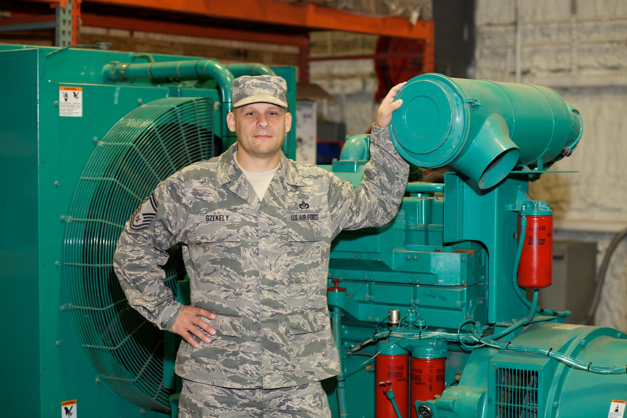 TYNDALL AIR FORCE BASE, Fla. -- Senior Master Sgt. Gary Szekely, force development manager for the power production career field, poses with a Cummins 400-kw power generator at the Air Force Civil Engineer Center here. Szekely recently won the Society of American Military Engineers Goddard Medal for contributions in military troop construction, base maintenance and contingency engineering during his recent deployment. (U.S. Air Force photo/Eddie Green)