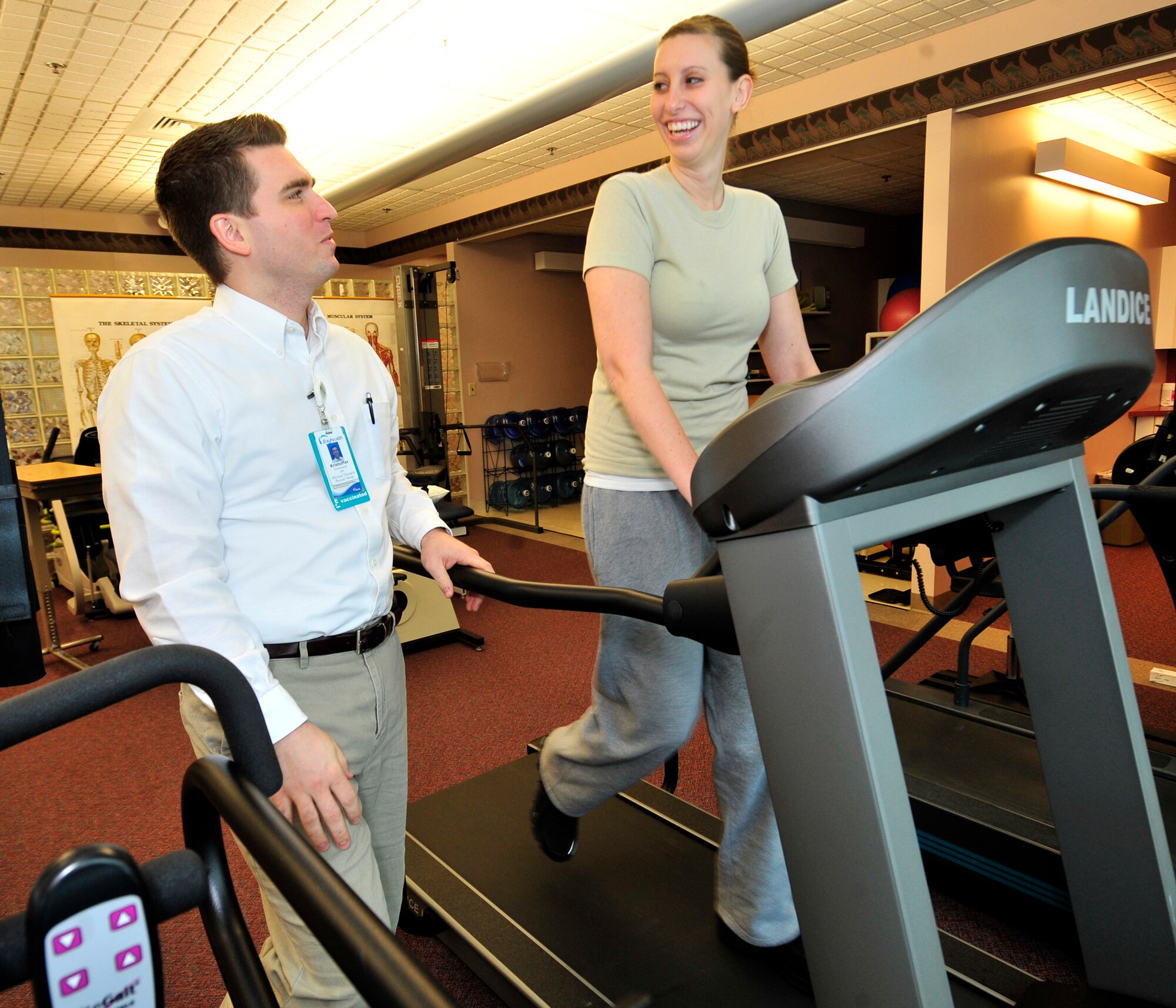 Lori Cord walks on a treadmill as Kristoffer Surdukowski, her physical therapist, looks on Feb. 1, 2013, at the Bayhealth Physical Therapy Center in Dover, Del. Walking is one of the activities that Cord must do to help her recover from Guillain-Barre Syndrome. (U.S. Air Force photo by Tech. Sgt. Chuck Walker)