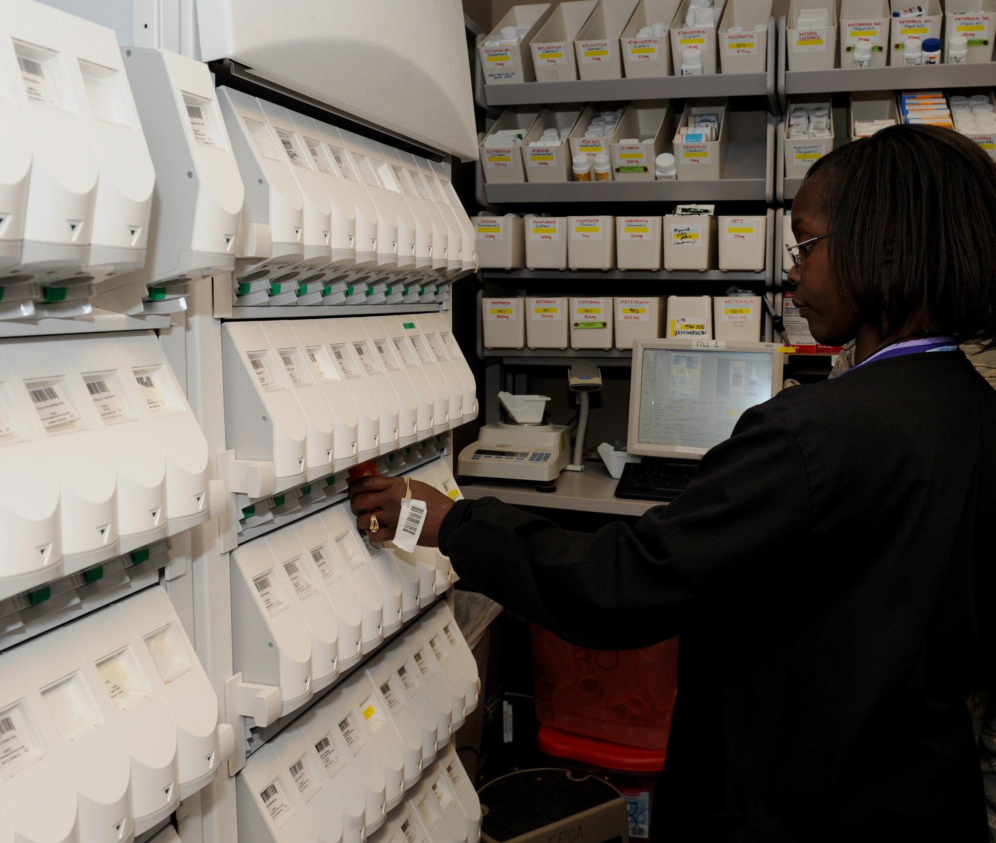 Terri Savage-Campbell, 2nd Medical Support Squadron pharmacy technician, fills a bottle with prescription pills at the base pharmacy on Barksdale Air Force Base, La., Feb. 4. The medication dispenser contains more than 100 prescription drugs that are commonly prescribed. This machine allows fast and accurate distribution of medication. (U.S. Air Force photo/Airman 1st Class Benjamin Gonsier)
