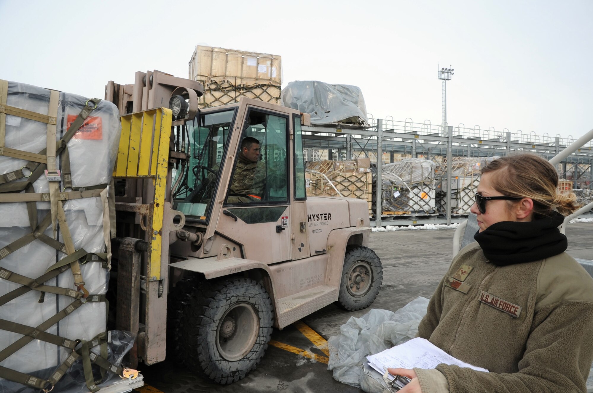 Senior Airman Lynn Libby, 455th Expeditionary Aerial Support Squadron air transport specialist, watches as Senior Airman Chris Cali takes a pallet of cargo into the storage area of the 455th EAPS freight yard. The yard has the capacity to hold 1,000 such pallets as they await forward transit. (U.S. Air Force photo/Staff Sgt. David Dobrydney)