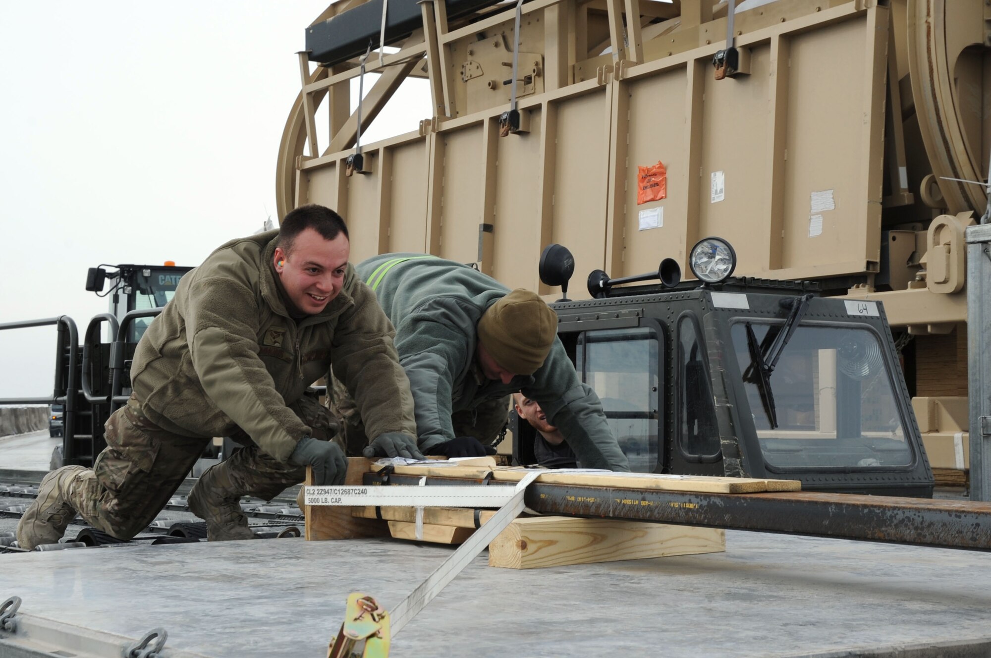Senior Airman Wes Simmons and Staff Sgt. Justin Klugh, 455th Expeditionary Aerial Port Squadron aerial porters, shift pallets that have just arrived on Bagram Airfield, Afghanistan, Feb. 5, 2013. The cargo on these pallets is to be distributed on base. (U.S. Air Force photo/Staff Sgt. David Dobrydney)