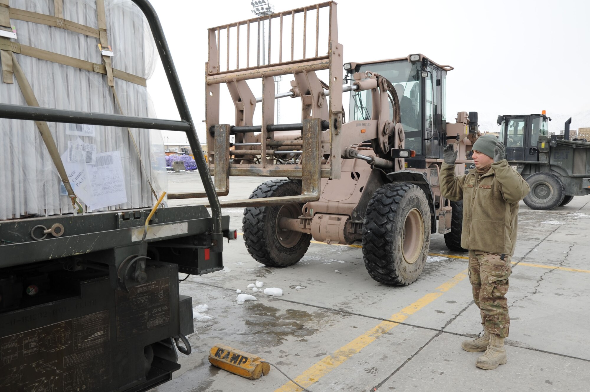 Senior Airman Wes Simmons, 455th Expeditionary Aerial Port Squadron aerial porter, guides a forklift as it offloads pallets that just arrived on Bagram Airfield, Afghanistan, Feb. 5, 2013. The Aerial Port freight yard saw 104,000 tons of cargo transit through over the past six months. (U.S. Air Force photo/Staff Sgt. Dobrydney)