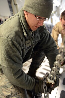 Airman 1st Class James Terronez, an aerial porter from Wichita, Kan., assigned to the 818th Contingency Response Group at Joint Base McGuire-Dix-Lakehurst, N.J., secures a French military vehicle on a U.S. Air Force C-17 Globemaster at Istres Air Base, France Feb. 4. The C-17's are airlifting French army supplies and equipment to Bamako, Mali, at the request of the French government. (U.S. Air Force photo by Senior Master Sgt. Sarah R. Webb/RELEASED)