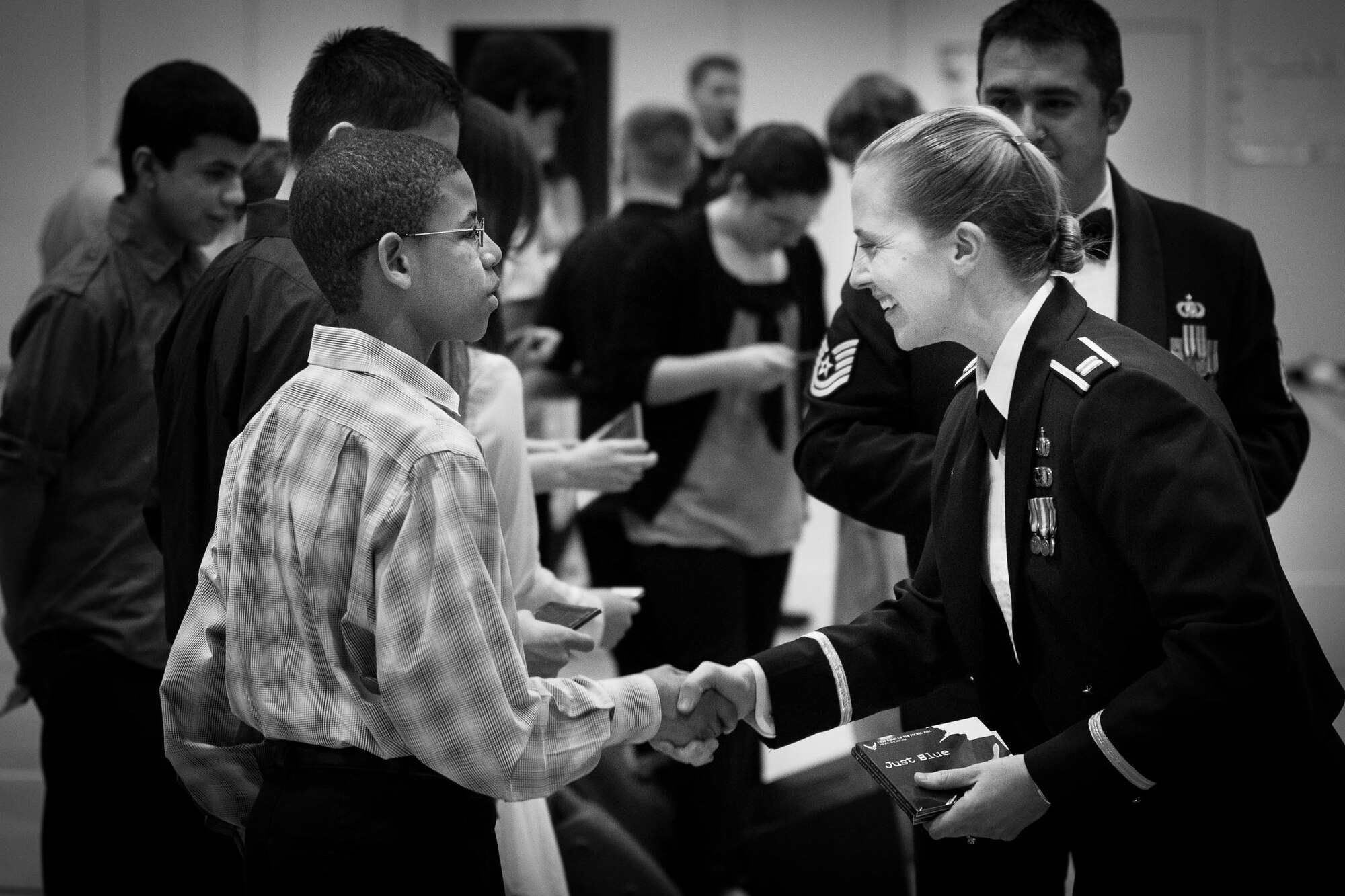 YOKOTA AIR BASE, Japan -- Capt. Haley Armstrong, Band of the Pacific-Asia commander, shakes hands and passes out the Pacific Showcase, Band of the Pacific-Asia jazz ensemble, "Just Blue" CD recording as a thank you to the students who played with Pacific Showcase earlier in the evening at the Yokota Middle School, Yokota Air Base, Japan, Jan. 30, 2013. (U.S. Air Force photo by Staff Sgt. Josh Voyles)