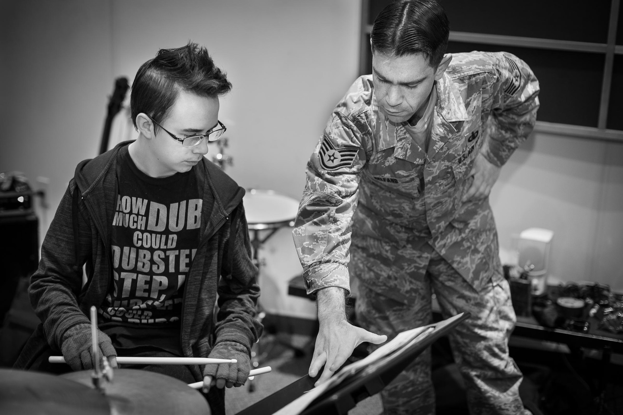YOKOTA AIR BASE, Japan -- Staff Sgt. Steven Helfand, Band of the Pacific-Asia percussionist, instructs Yokota Middle School student Brandon Chandler on his music at the Band of the Pacific-Asia rehearsal room, Yokota Air Base, Japan, Jan. 30, 2013. Students received instrumental lessons from the Air Force musicians to fine tune parts before the joint concert that evening. (U.S. Air Force photo by Staff Sgt. Josh Voyles)