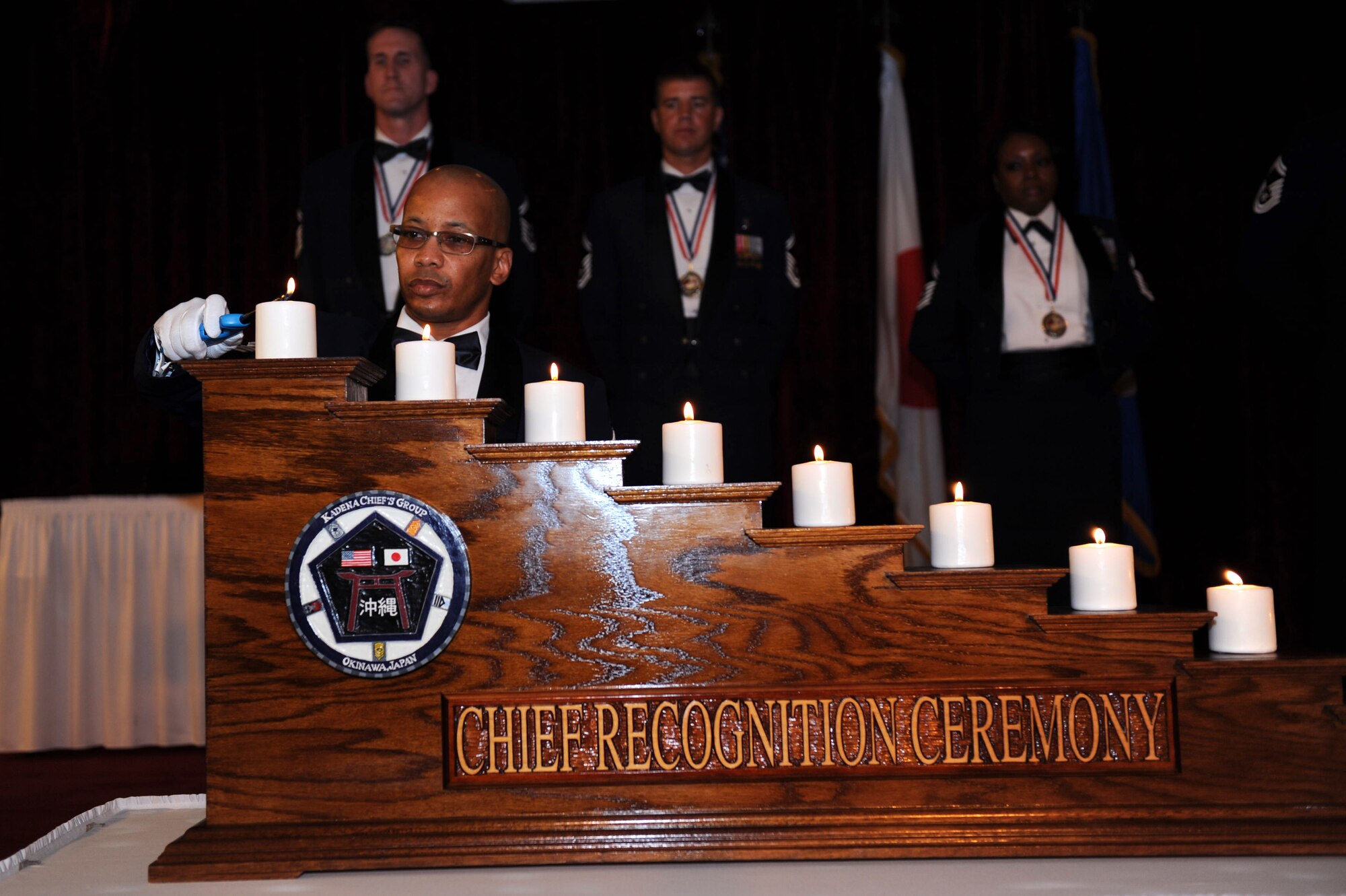 U.S. Air Force Chief Master Sgt. William Brown, 18th Operations Support Squadron superintendent, lights the last candle representing the nine enlisted ranks at the chief recognition ceremony at the Rocker NCO Club on Kadena Air Base, Japan, Feb. 1, 2013. Enlisted service members also placed corresponding chevrons on a chief master sergeant rank insignia. (U.S. Air Force photo/Airman 1st Class Hailey R. Davis)