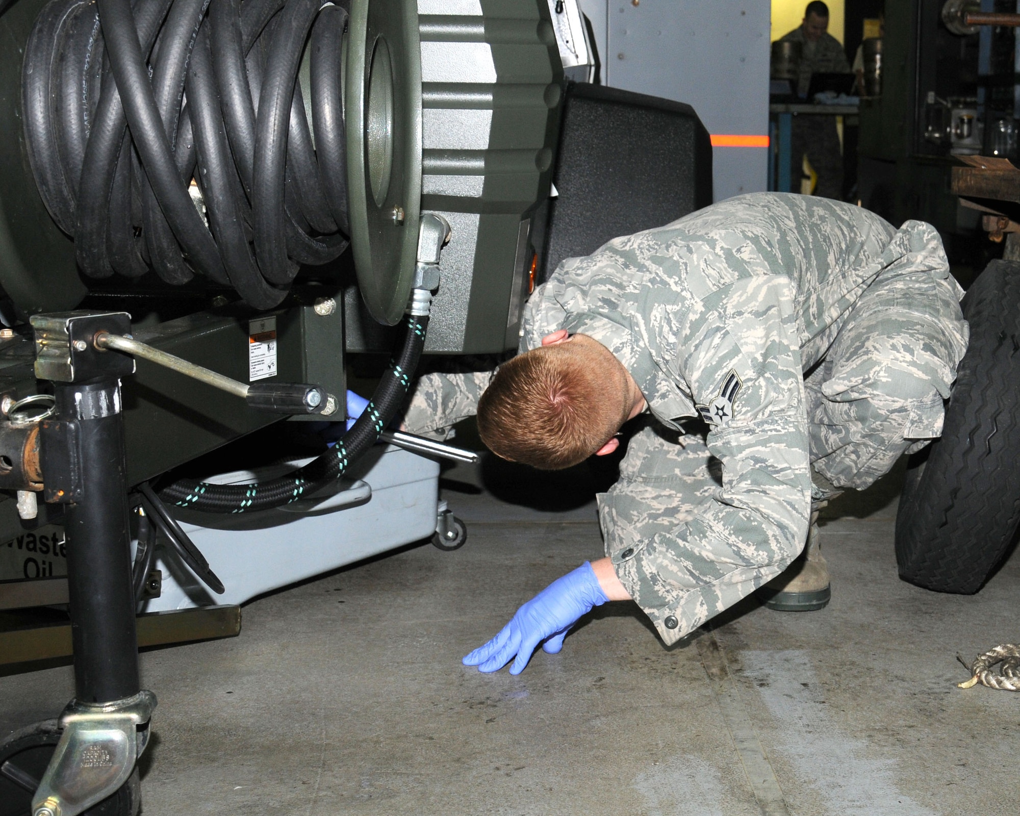 Airman 1st Class Christopher Garrison, 100th Maintenance Squadron Aerospace Ground Equipment apprentice from McKinney, Texas, changes the compressor oil on a piece of equipment Jan. 30, 2013, at RAF Mildenhall, England. The section has 726 assigned pieces of AGE and supplies aircraft equipment to all flying units on the base. (U.S. Air Force photo by Gina Randall/Released)