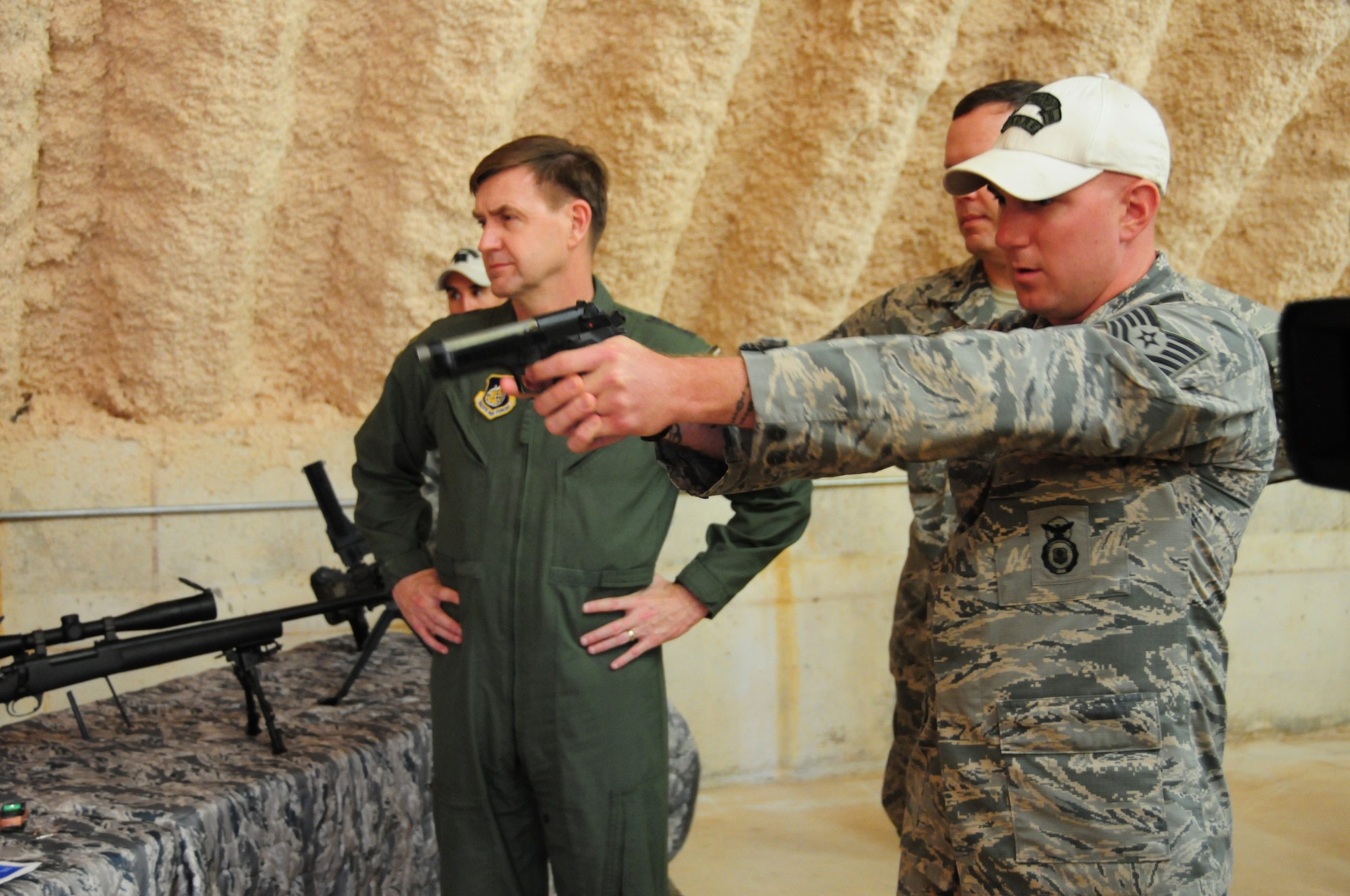 Tech Sgt. Michael Dugan, 736th Security Forces Squadron, fires a 9 millimeter Beretta with simulated rounds for Lt. Gen. Stephen Hoog, U.S. Air Force Alaskan Command and 11th Air Force commander, demonstrating different techniques to control a suspect at Northwest Field, Guam, Feb. 1. During his trip here, General Hoog visited with the 736th Security Forces Squadron, 36th Mobility Response Squadron, 36th Medical Group and several other squadrons from Andersen, and got a first-hand look at what Andersen Airmen bring to the fight within U.S. Pacific Command area of responsibility. (US Air Force photo by Senior Airman Robert Hicks/Released)