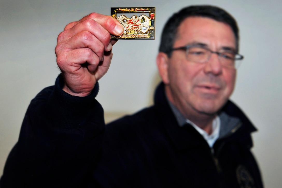 U.S. Deputy Defense Secretary Ashton B. Carter holds up a unit coin after handing out his own coins to U.S. soldiers on a Turkish army base in Gaziantep, Turkey, Feb. 4, 2013.