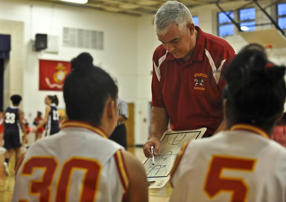 Paul Roy, head coach, Quantico Middle/High School Lady Warriors Varsity Basketball Team, talks to his girls about plays he wants them to run during a Delaney Athletic Conference game against the Fredericksburg Academy Falcons at Quantico on Jan. 30. The Warriors weren’t able to keep the Falcons from outscoring them in the third quarter.