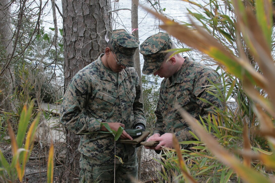 Cpl. Adam Mastrogiovanni and Lance Cpl. Larry Holmes, gunners with 2nd Low Altitude Air Defense Battalion, consult a defense advanced GPS receiver during a land navigation exercise here Jan. 31. The land navigation exercise was part of the team leader course, which covers multiple skill sets in classroom and practical application scenarios, including aircraft identification, rules of engagement, quick reaction drills and live-fire exercises. 