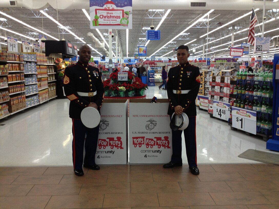 Staff Sgt. Royce D. Kelley, Headquarters and Headquarters Squadron adjutant, and Cpl. Manuel S. Palma, an H&HS administration clerk, man a Toys for Tots donation site Oct. 18. Both Marines volunteered to help with the Cherry Point Toys for Tots drive. Kelley was awarded the Single Marine Program’s Toys for Tots Volunteer of the Year award. 