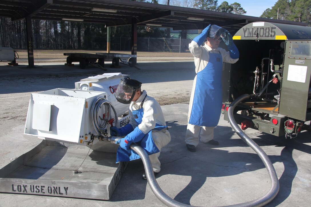 Lance Cpl. Daniel Hernandez, right, and Lance Cpl. Alexander Guajardo, work on attaching a hose to both tanks as they work on filling a 50-gallon tank with liquid oxygen outside the cryogenics compound at Cherry Point Jan. 22. Both are cryogenic technicians with Marine Aviation Logistics Squadron 14.