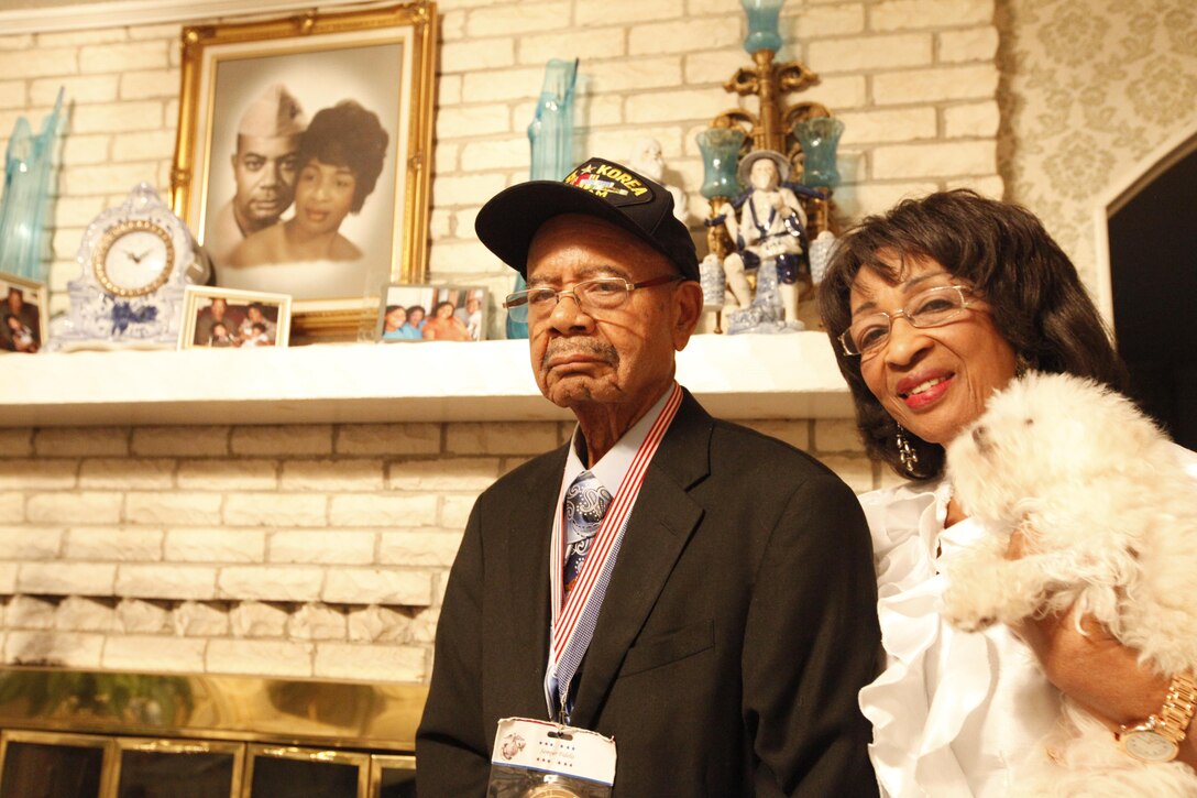 Montford Point Marine, retired Master Sgt. Turner Blount, stands with his wife Sadie, near a family photo of the couple taken decades ago while Blount was enlisted in the Marine Corps. 