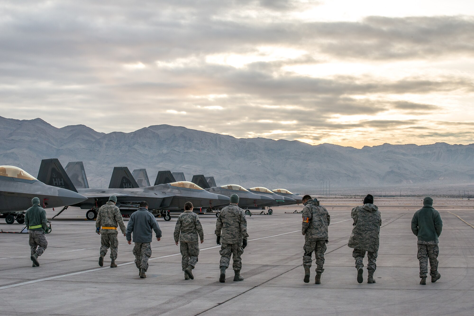 Maintainers deployed from the 15th Wing and 154th Wing, Air National Guard, conduct a foreign object debris walk on the flightline at Nellis Air Force Base, Nevada.  The crews and aircraft were deployed in support of Red Flag 13-2 from 21 Jan. through 1 Feb. Red Flag is an advanced aerial combat training exercise that spans two weeks and is held at Nellis or Eielson Air Force Base, Alaska. The exercises host air crews from various U.S. and allied military units and air frames. (Courtesy photo/Ervin Booker)