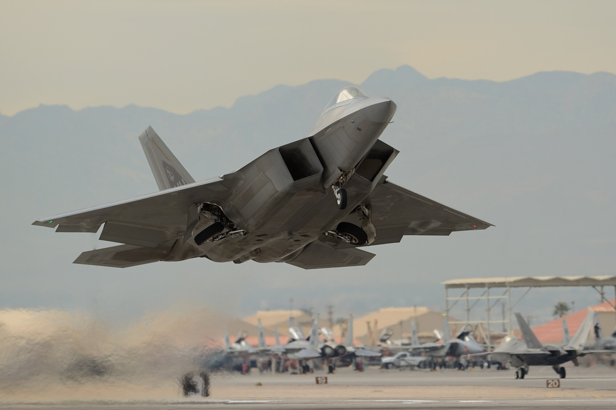 A Hawaiian Raptor, assigned to the 154th Wing, Hawaii Air National Guard, takes off from Nellis Air Force Base, Nevada, during Red Flag 13-2 on Jan. 23, 2013.  Red Flag is the largest and most complex full-scale Red Flag exercise to date.  Each Red Flag exercise is an advanced aerial combat training opportunity that spans two weeks and is held at Nellis or Eielson Air Force Base, Alaska. The exercises host air crews from various U.S. and allied military units and air frames.  (Courtesy Leading Edge Images photo/Glenn Bloore)  