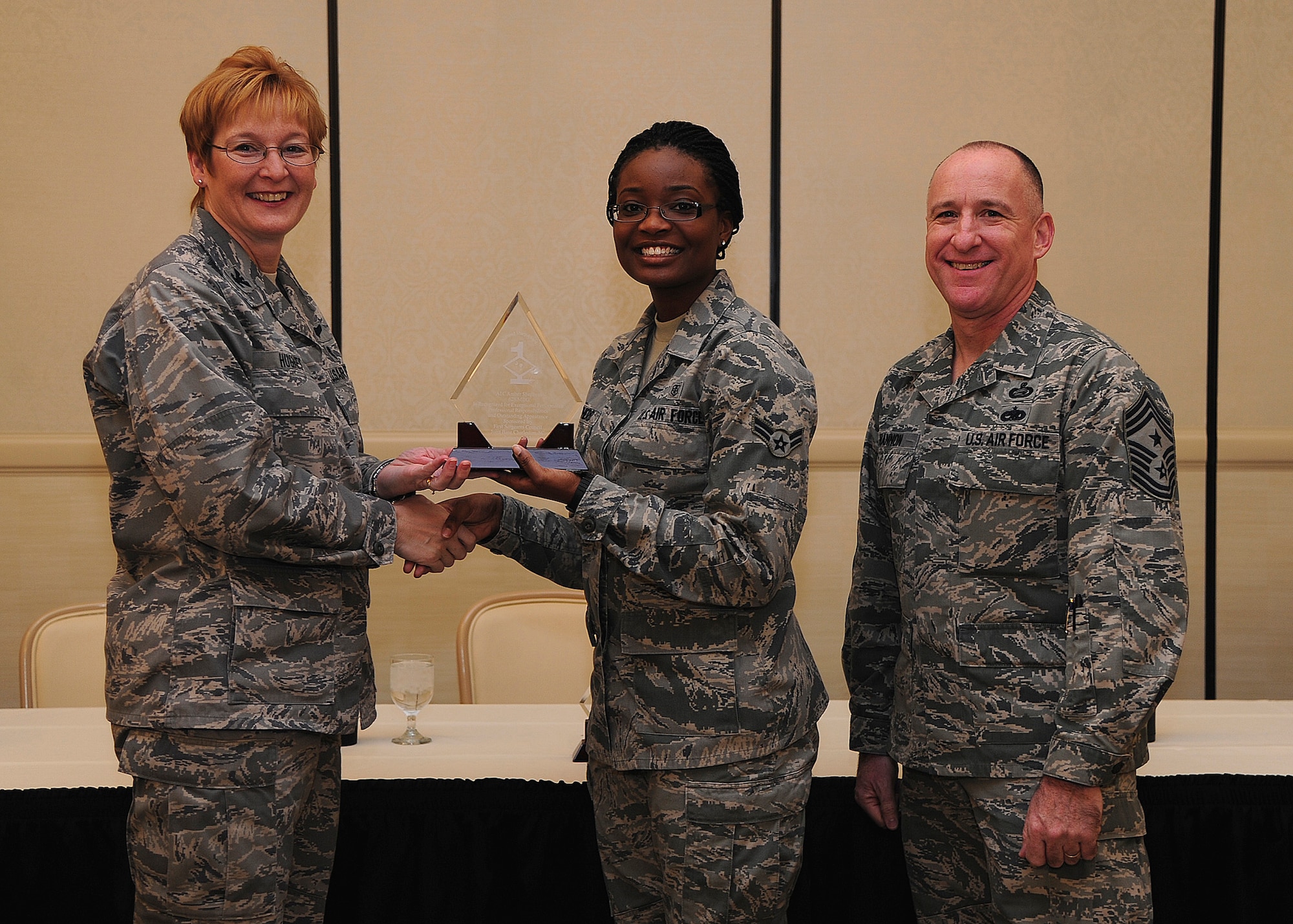 Colonel Judith Hughes, 628th Medical Group commander, and Chief Master Sgt. Al Hannon, 628th Air Base Wing command chief, recognize Airman 1st Class Amber Shepherd, 628th MDG patient travel medical technician, as a Diamond Sharp award winner during a ceremony at the Charleston Club, Feb. 4, 2013, at Joint Base Charleston - Air Base, S.C. Diamond Sharp awardees are Airman chosen by their first sergeants for their excellent performance. (U.S. Air Force photo/ Staff Sgt. Rasheen Douglas)