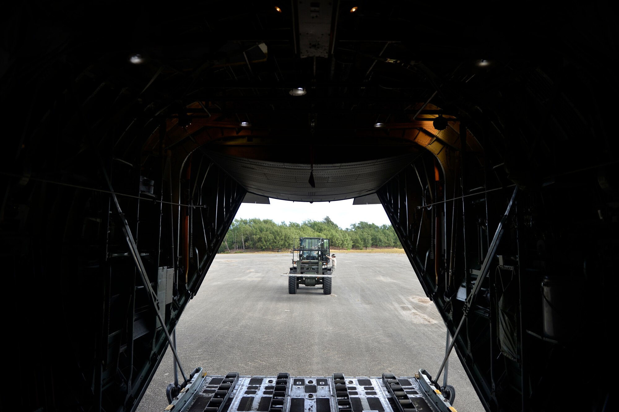 U.S. Air Force Airmen from the 36th Contingency Response Group prepare to load equipment onto a C-130H at Northwest Field, Guam while supporting Cope North 13, Feb. 6, 2013.  The aircraft then delivered the cargo to Andersen Air Force Base, Guam after stops at the islands of Tinian and Saipan. Cope North is an annual air combat tactics, humanitarian assistance and disaster relief exercise designed to increase the readiness and interoperability of the U.S. Air Force, Japan Air Self-Defense Force and Royal Australian Air Force. (U.S. Air Force photo by Senior Airman Matthew Bruch/Released)