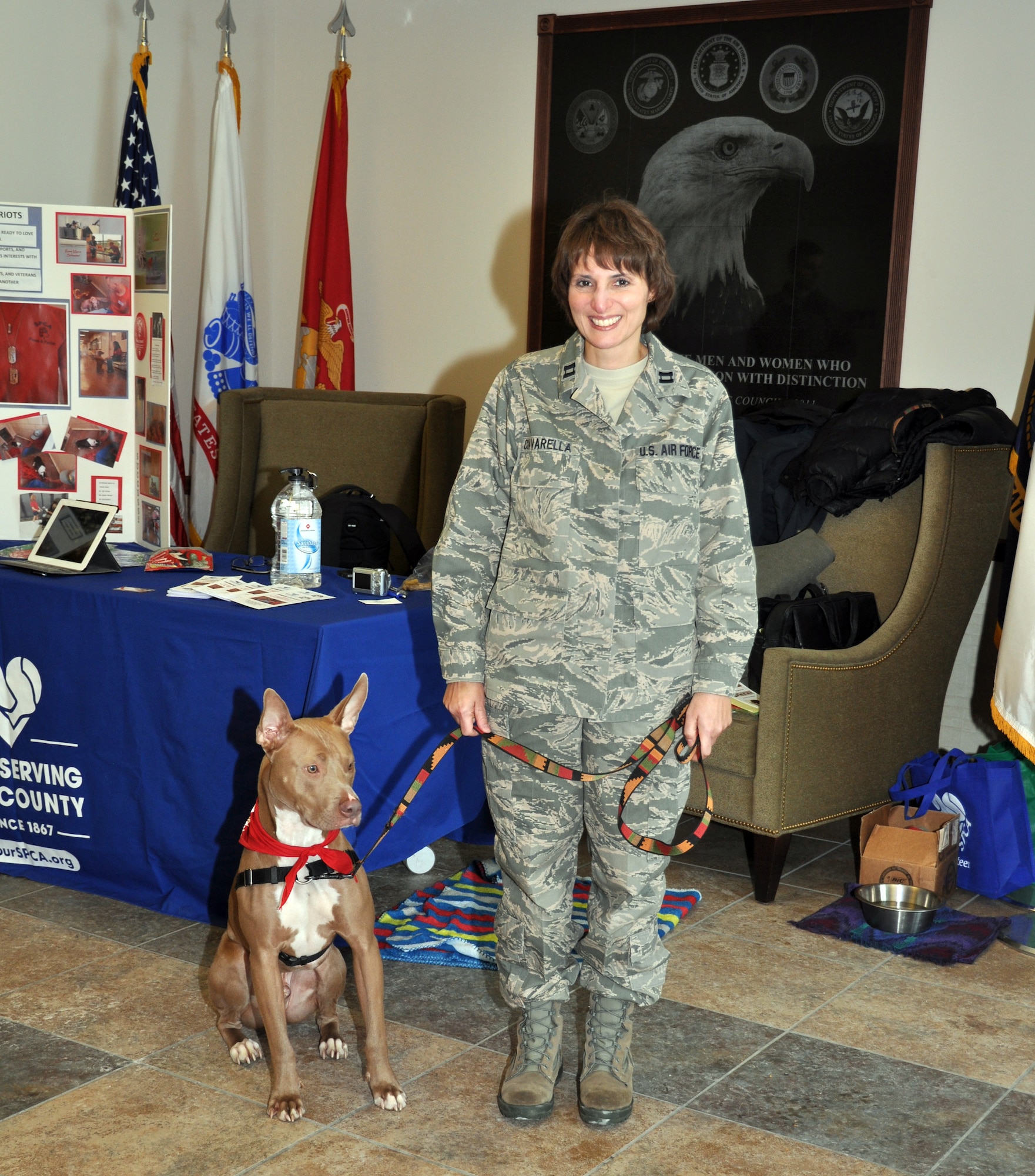 Capt. Lisa Ciavarella, 914th Force Support Squadron Services Sustainment Flight, poses with Auggie here at the Niagara Falls Air Reserve Station, February 2, 2013. Auggie is a working dog for the Society for the Prevention of Cruelty to Animals who is representing “Paws for Patriots,” an organization which unites U.S. military veterans and animals to heal and bond with each other. (U.S. Air Force photo by Staff Sgt. Stephanie Clark)