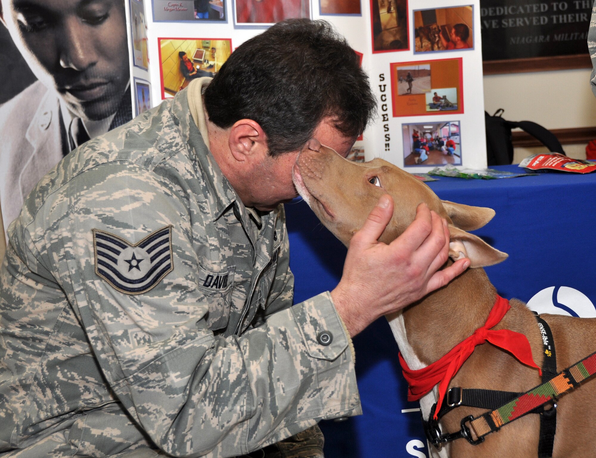 Tech. Sgt. James Davide, 914th Aircraft Maintenance Squadron, says hello to Auggie, a working dog for the Society for the Prevention of Cruelty to Animals, February 2, 2013 at the Niagara Falls Air Reserve Station, N.Y.  Auggie is representing “Paws for Patriots,” an organization which unites U.S. military veterans and animals to heal and bond with each other. (U.S. Air Force photo by Staff Sgt. Stephanie Clark)