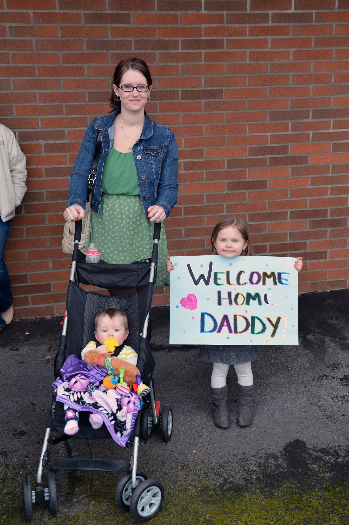 Loved ones of Senior Airman Johnny Williams, 10th Airlift Squadron loadmaster, wait for his arrival from a deployment Feb. 5, 2012, at Joint Base Lewis-McChord, Wash. The 10th AS, accompanied by Airmen from Elmendorf Air Force Base, Alaska, and Joint Base Pearl Harbor-Hickam, Hawaii, were deployed as the 817th Expeditionary Airlift Squadron. (U.S. Air Force photo/Staff Sgt. Jason Truskowski)