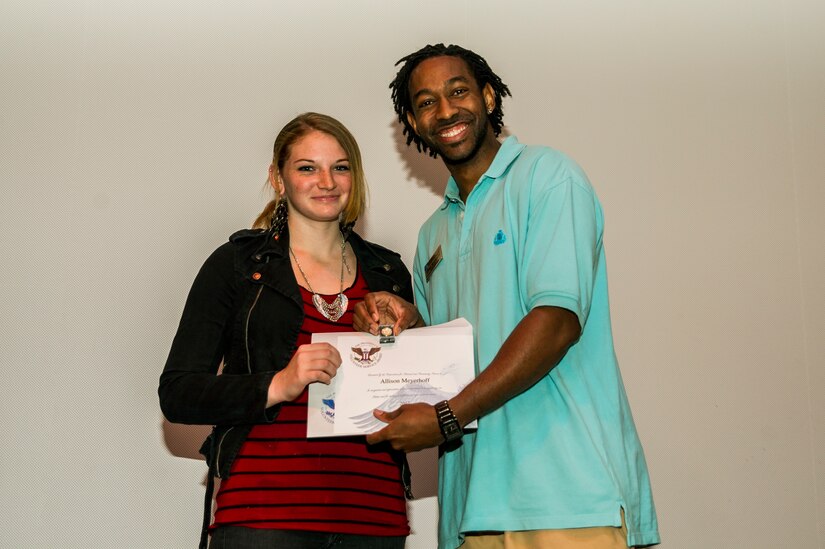 Allison Meyerhoff accepts an award from Lamar Moorehead, Youth Programs teen coordinator, during the Youth Programs Volunteer Recognition Ceremony Jan. 30, 2013, at Joint Base Charleston - Weapons Station, S.C. Meyerhoff volunteered 288 hours as a Junior Staff Volunteer with the School Age Summer Camp Program. More than 15 members from Team Charleston's community were honored during the ceremony. (U.S. Air Force photo/ Senior Airman George Goslin)