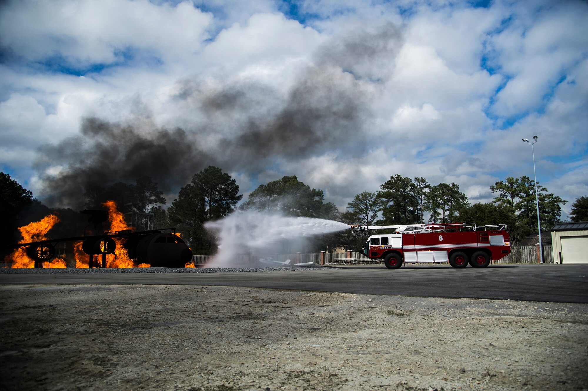 A 628th Civil Engineer Squadron fire truck shoots water at the flames on a static training aircraft Jan. 30, 2013, at Joint Base Charleston - Air Base, S.C. During the live fire burn exercise, firefighters practiced shooting precision bursts of water to extinguish the fire. This training is part of preparation for real world emergencies. (U.S. Air Force photo/Staff Sgt. Rasheen Douglas)
