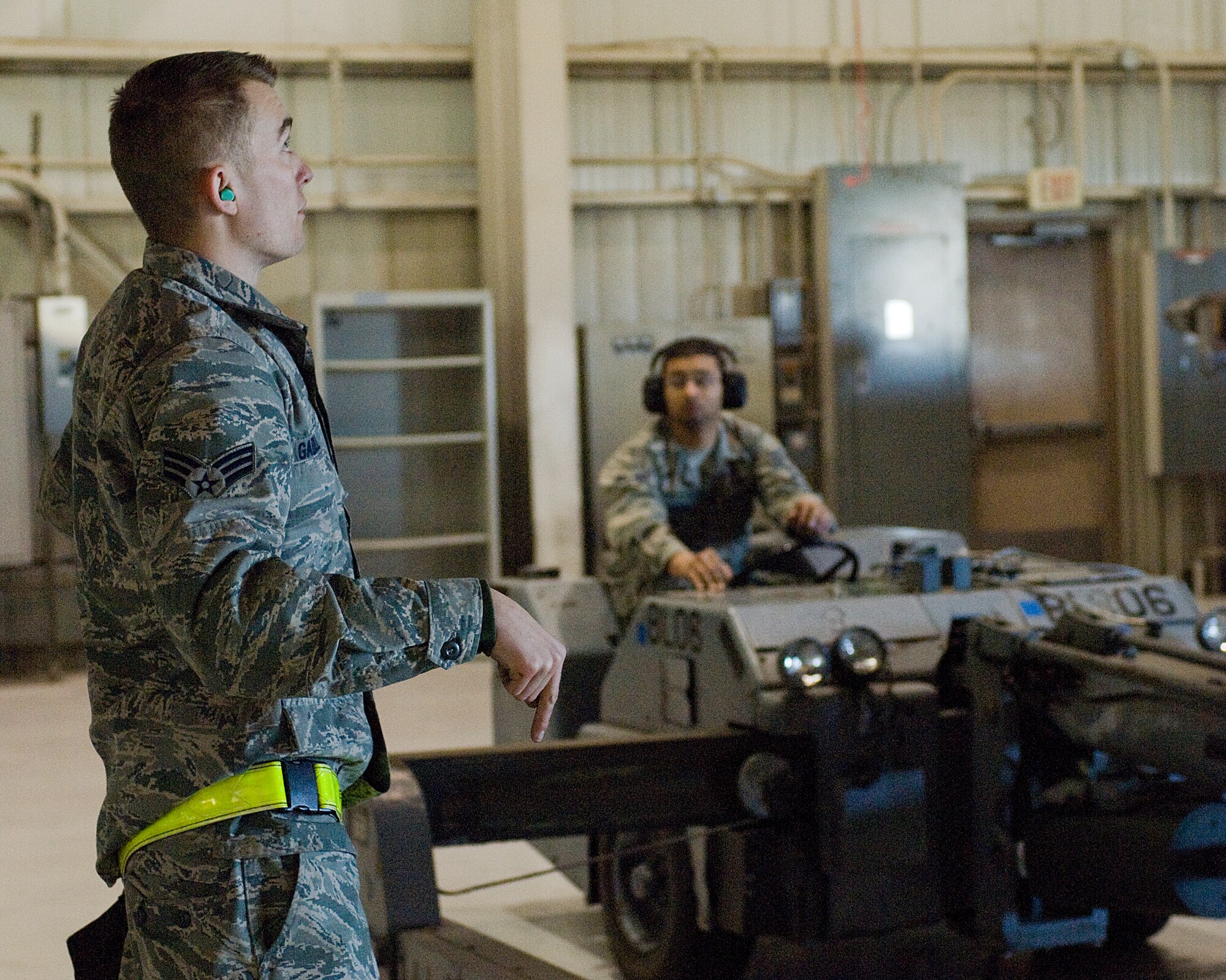 Senior Airman Phillip Gadell, 7th  Aircraft Maintenance Squadron, gives hand signals to lower the munitions lift during the Weapons Load Crew of the Year competition Feb. 1, 2013, at Dyess Air Force Base, Texas.  The competition was comprised of loading four different munitions into a B-1 simulator while being evaluated on their use of checklists, safety procedures, and overall speed. (U.S. Air Force photo by Airman 1st Class Kylsee Wisseman/Released)