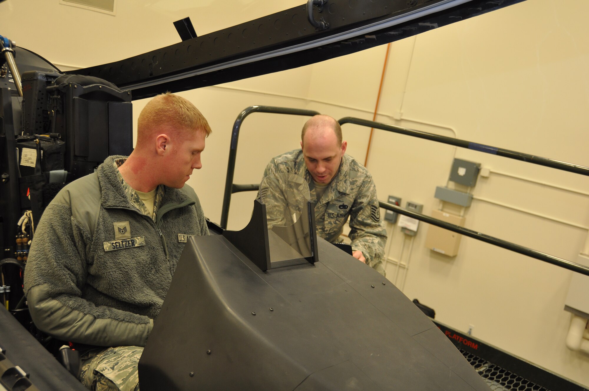 Staff Sgt. Shane Seltzer, 3rd Aircraft Maintenance Squadron F-22 avionics specialist, and Tech. Sgt. Alan Maisonet, 3rd Maintenance Operations Squadron, practice performing emergency procedures in an F-22 cockpit trainer. Seltzer was one of three F-22 maintenance personnel certified to perform F-22 engine runs here at Joint Base Elmendorf-Richardson Feb. 1. (U.S. Air Force Reserve Photo/Tech. Sgt. Dana Rosso)
