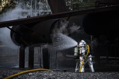 Michael Ruey and Senior Airman Justin Fleishmann, 628th Civil Engineer Squadron firefighters, pour water on a training aircraft Jan. 30, 2013, at Joint Base Charleston - Air Base, S.C. The static training aircraft allows 628th CES firefighters the opportunity to practice their fire response abilities in case of an actual emergency. (U.S. Air Force photo/Staff Sgt. Rasheen Douglas)