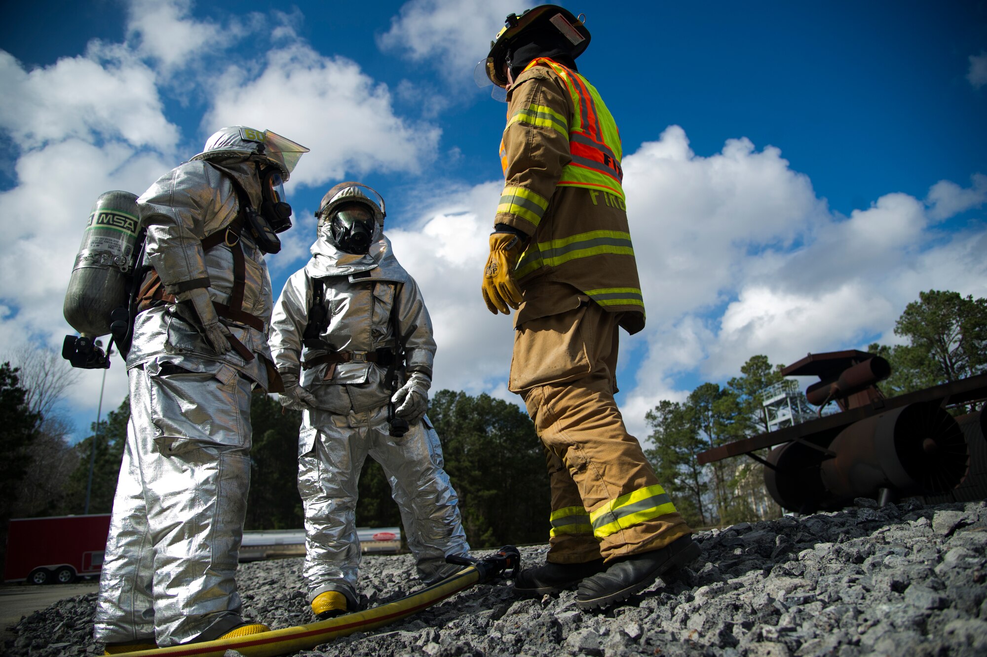 Lead Firefighter Mark Johnson (right) talks to Senior Airman Justin Fleishmann and Michael Ruey, after evaluating their response to eliminating the fire from the static training aircraft Jan. 30, 2013, at Joint Base Charleston - Air Base, S.C. Johnson, Fleishmann and Ruey are firefighters from the 628th Civil Engineer Squadron. The static training aircraft allows fire fighters the opportunity to practice their fire response abilities in case of an actual emergency. (U.S. Air Force photo/Staff Sgt. Rasheen Douglas)