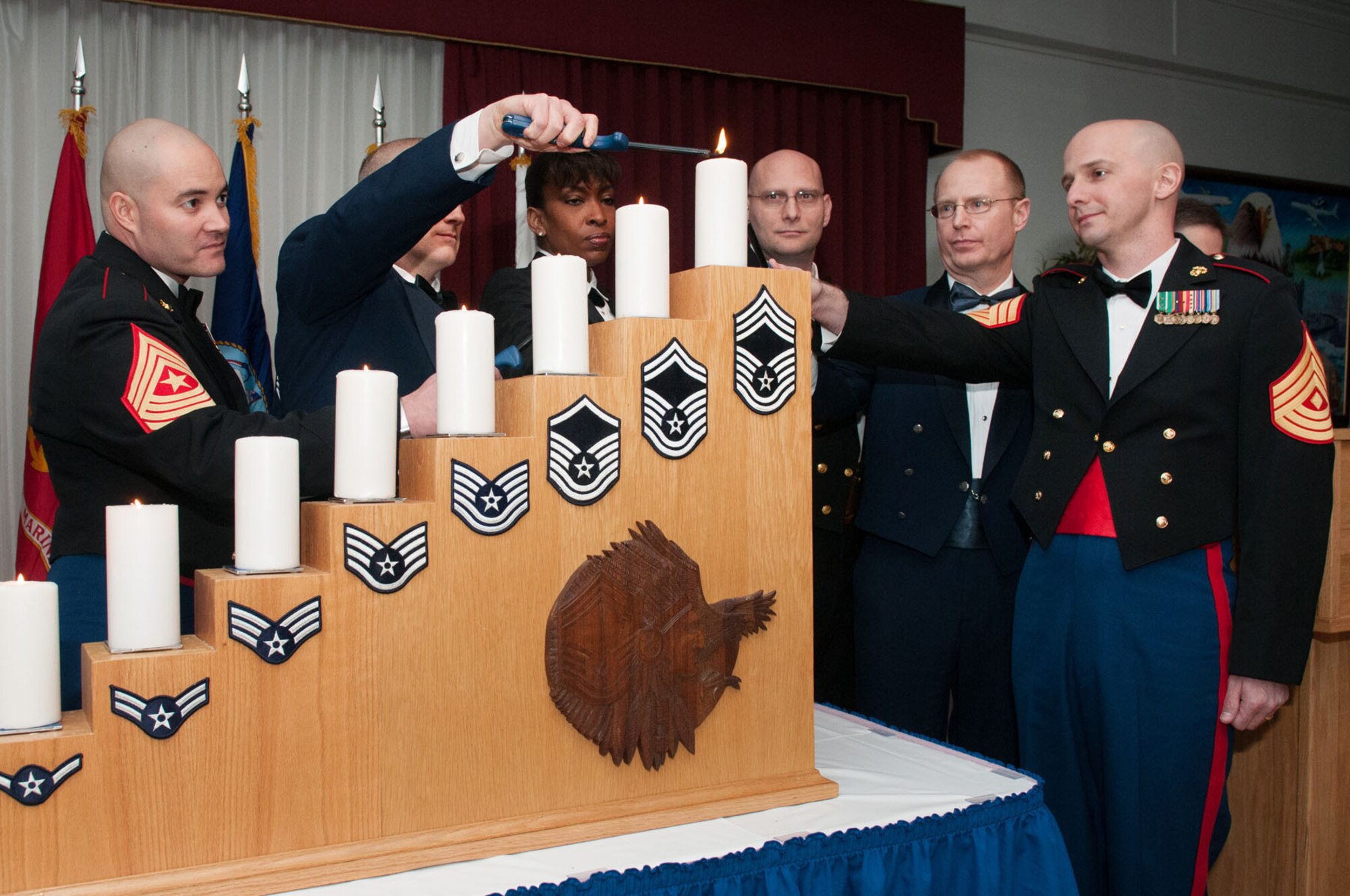 HANSCOM AIR FORCE BASE, Mass. -- (from left to right) Sgt. Maj. Alfredo Franco, Senior Master Sgt. Robert Johnson, Master Chief Yeoman Rashaun Morris, Master Chief Yeoman Scott Ayriss, Chief Master Sgt. Michael Mousseau and 1st Sgt. Rodger Newcomb light the top candle, signifying they have obtained the highest enlisted rank in the armed forces, during the Joint Service E-9 Recognition Ceremony at the Minuteman Commons Feb. 1. Hosted by the 66th Air Base Group and the Hanscom Chief's Group, the ceremony recognized Air Force, Coast Guard and Marine Corps members from throughout the region. (U.S. Air Force photo by Rick Berry)