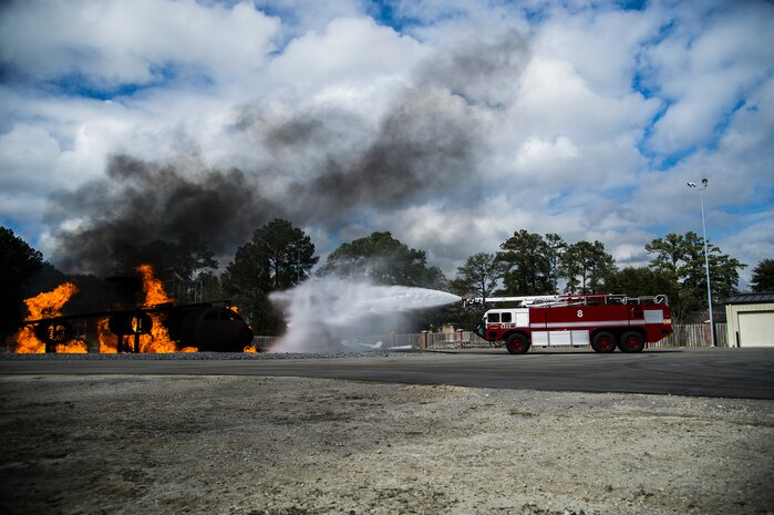 A 628th Civil Engineer Squadron fire truck shoots water at the flames on a static training aircraft Jan. 30, 2013, at Joint Base Charleston - Air Base, S.C. During the Live Fire Burn exercise, firefighters practiced shooting precision bursts of water to extinguish the fire. This training is part of preparation for real world emergencies. (U.S. Air Force photo/Staff Sgt. Rasheen Douglas)