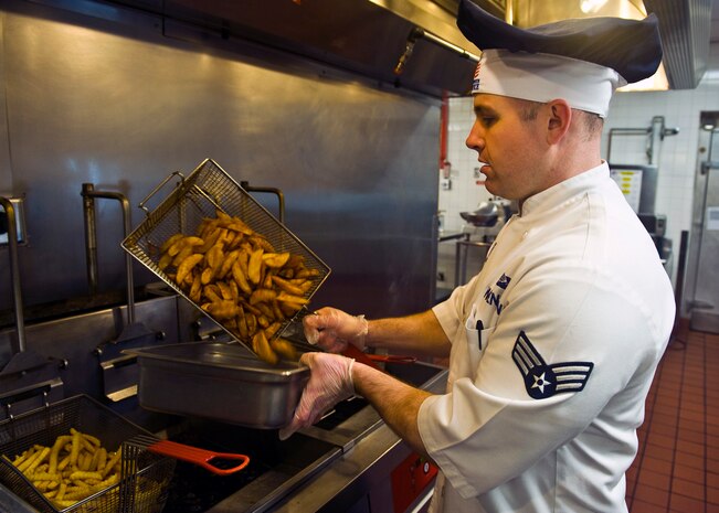U.S. Air Force Senior Airman Matthew Swenson, 99th Force Support Squadron services journeyman, pours potato wedges into a bin at the Crosswinds Dining Facility, Feb. 5, 2013, on Nellis Air Force Base, Nev. The 99th FSS is currently in the running for this year's Hennessy Award.  The Hennessy  Award is presented to Air Force installations having the best food service program in the Air Force. (U.S. Air Force photo/Senior Airman Brett Clashman)