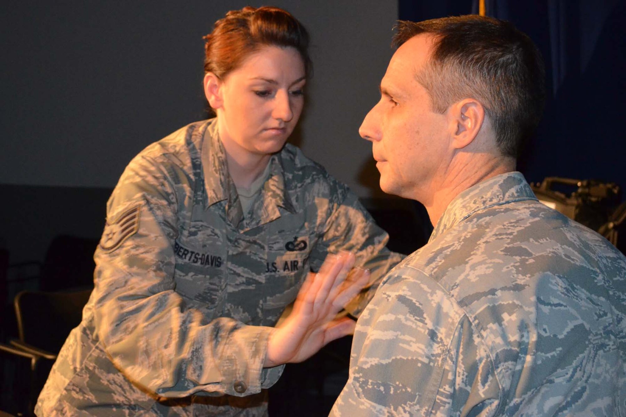 Staff Sgt. Holly Roberts-Davis, 3rd Combat Camera Squadron, adjusts the microphone on Col. Jeffrey T. Pennington's, 433rd Airlift Wing commander, uniform prior to taping a message to 433rd AW personnel concerning the use of removeable media on government networks at the 3rd CCS television studio on Joint Base San Antonio-Lackland Texas on Feb. 5, 2013. (U.S. Photo/ Maj. Tim Wade)
