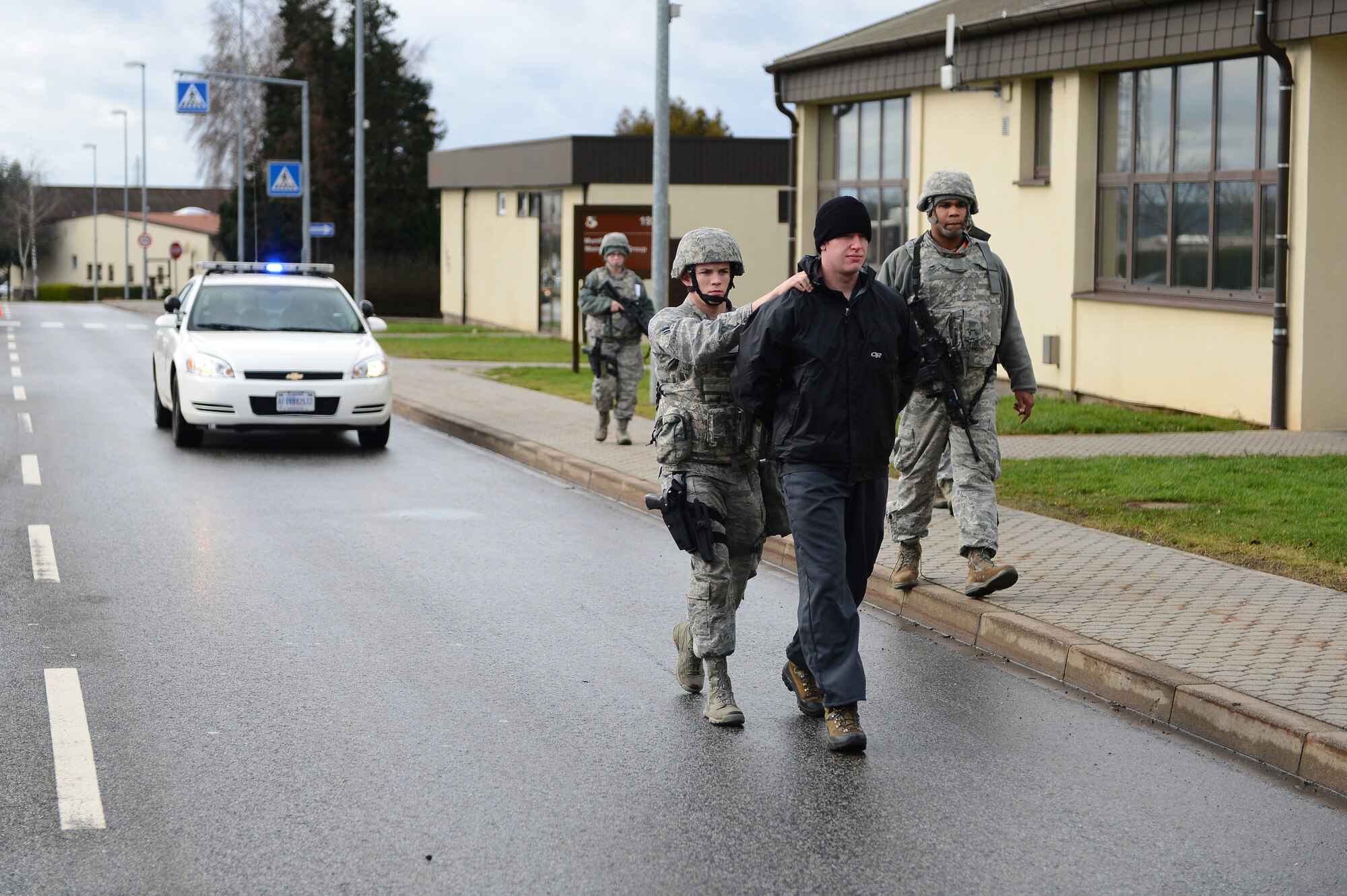 SPANGDAHLEM AIR BASE, Germany – U.S. Air Force Airman 1st Class Marc Payton, 52nd Security Forces Squadron patrolman from Houston, brings simulated perpetrator U.S. Air Force Senior Airman Justin Gordin, 52nd Operations Support Squadron survival, evasion, resistance and escape specialist from Pittsburgh, Mich., into a decontamination area during a base exercise Feb. 5, 2013. The exercise tested first responders’ tactics, techniques and procedures used to keep base members safe from a suspicious package and hazardous materials situations. (U.S. Air Force photo by Senior Airman Dillon Davis/Released)