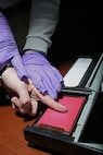 U.S. Air Force Detective Louie Cathro, 902nd Security Forces Squadron Criminal Investigations, completes a latent fingerprint of a service member Jan. 29, 2013, at Joint Base San Antonio-Randolph. (U.S. Air Force photo by Joshua Rodriguez/ Released)